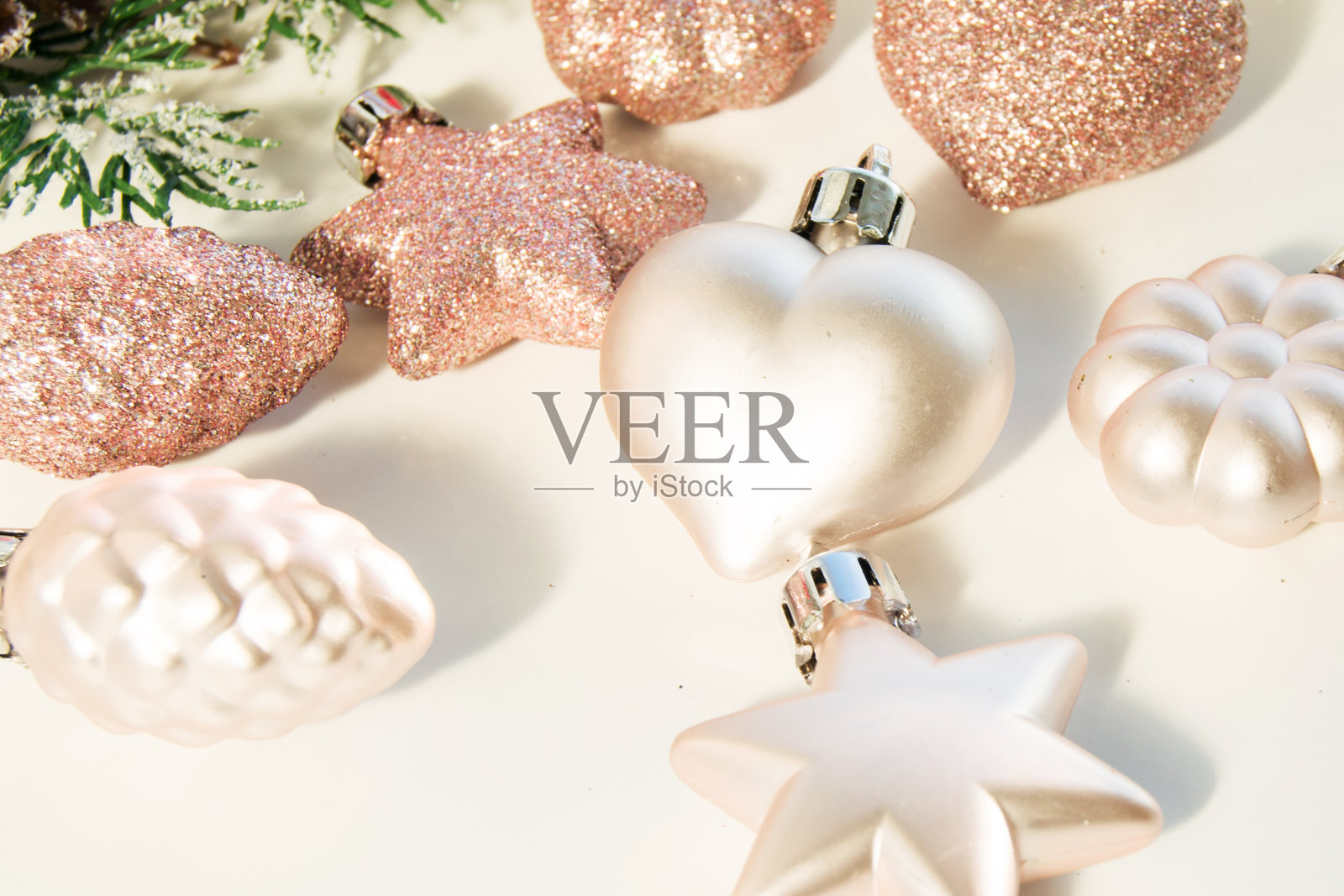 圣诞玩具-粉色闪亮的球在一个浅的背景和一个散焦前景。新年或圣诞贺卡、请柬。照片摄影图片