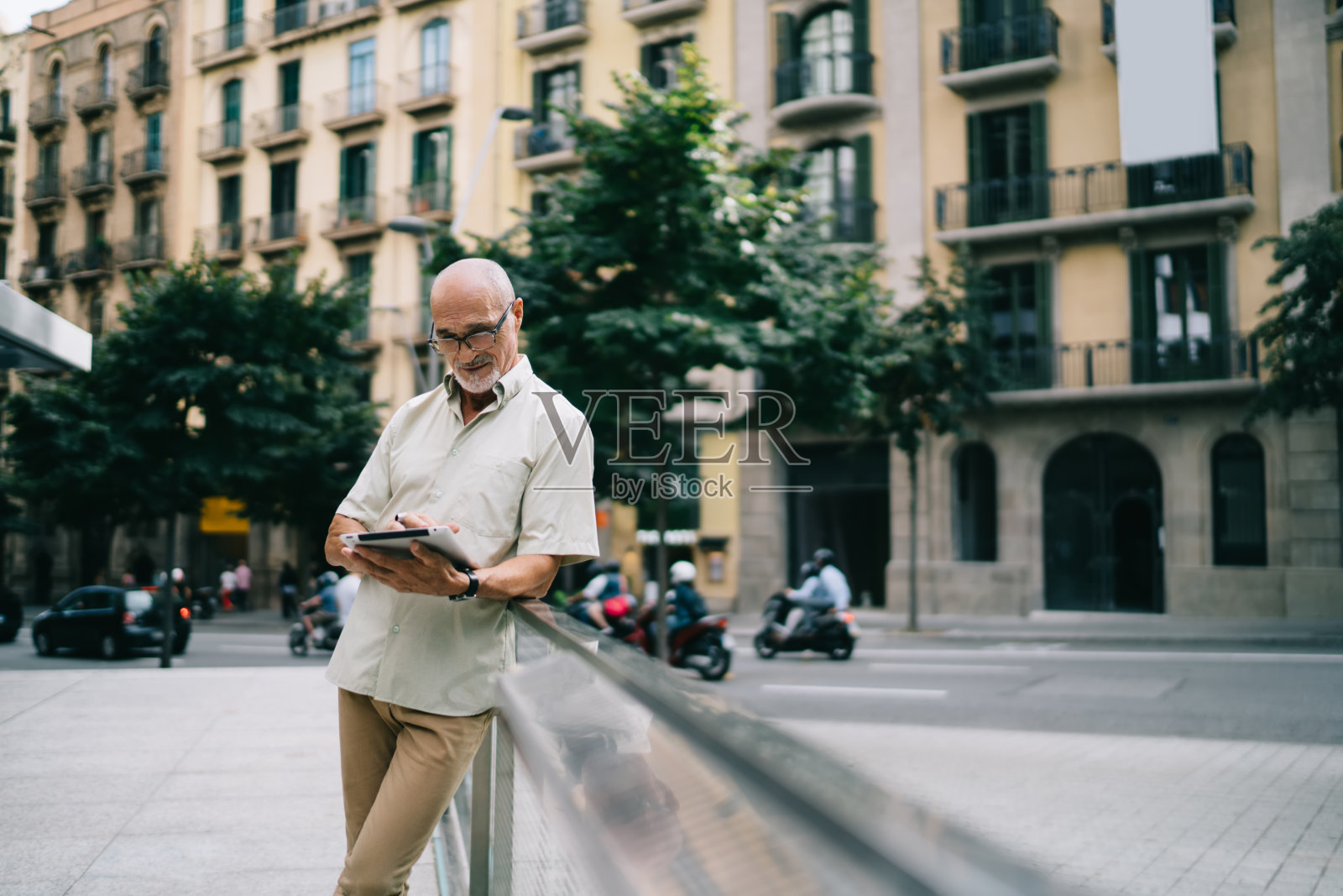 专注的老人在街上使用平板电脑照片摄影图片