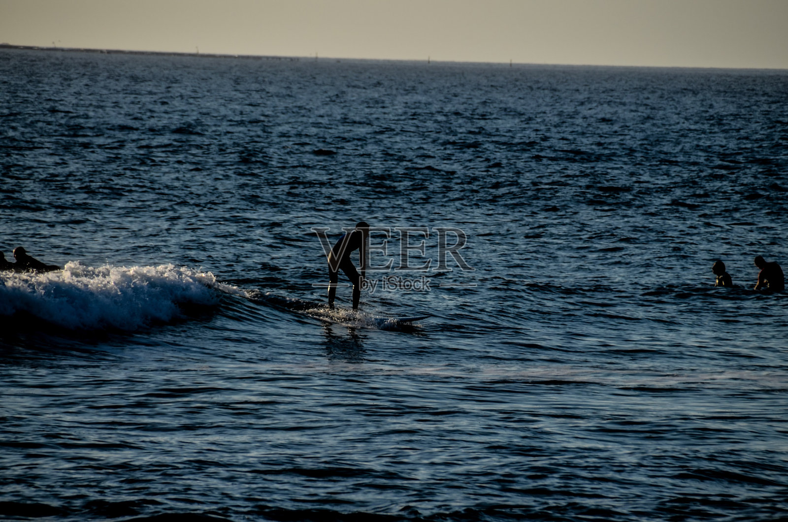 夕阳下的剪影冲浪者照片摄影图片