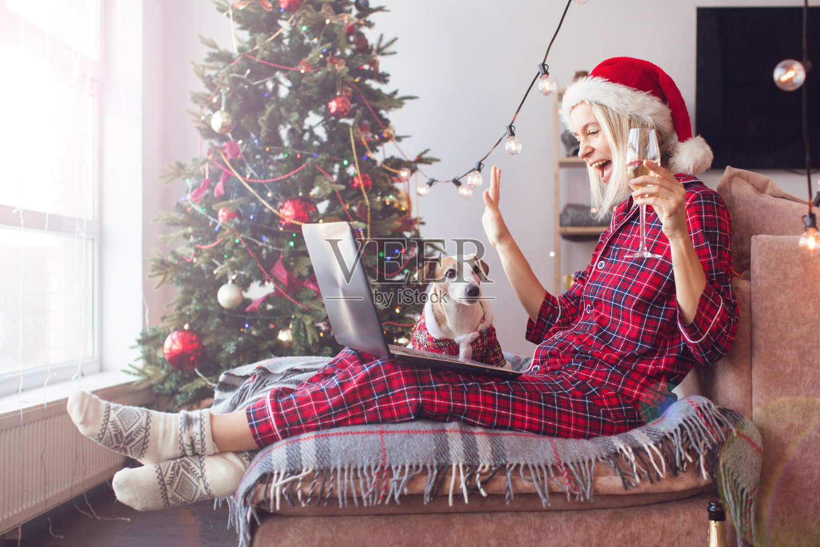 一名女子在圣诞树旁用笔记本电脑进行视频通话照片摄影图片