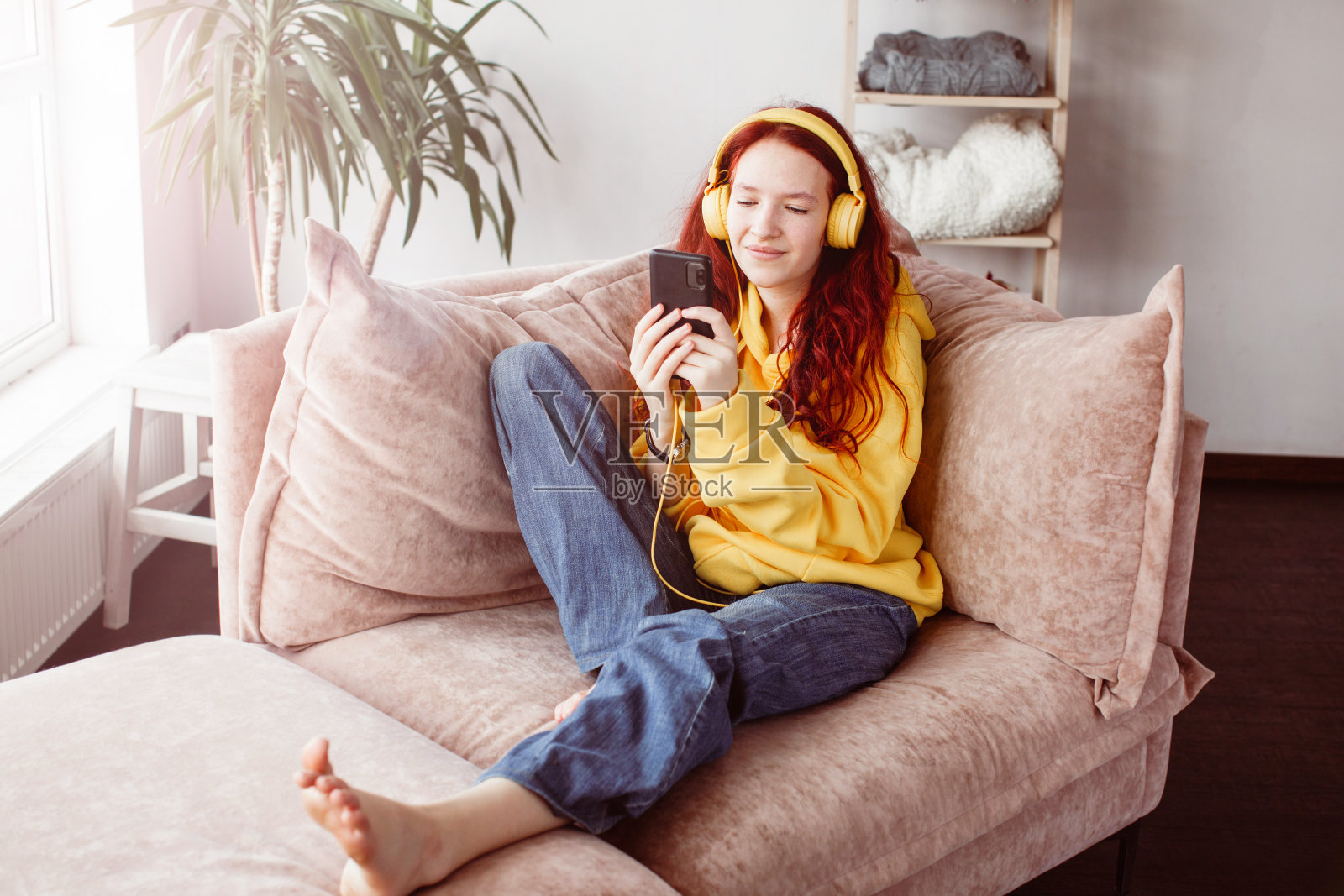 微笑的少女戴着耳机在网上电话聊天照片摄影图片