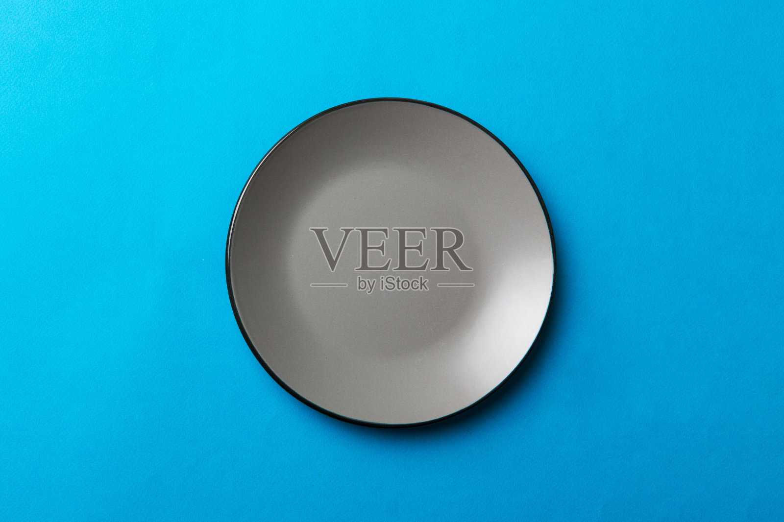 顶视图孤立的彩色背景空圆灰色盘子的食物。为你的设计腾出空间照片摄影图片