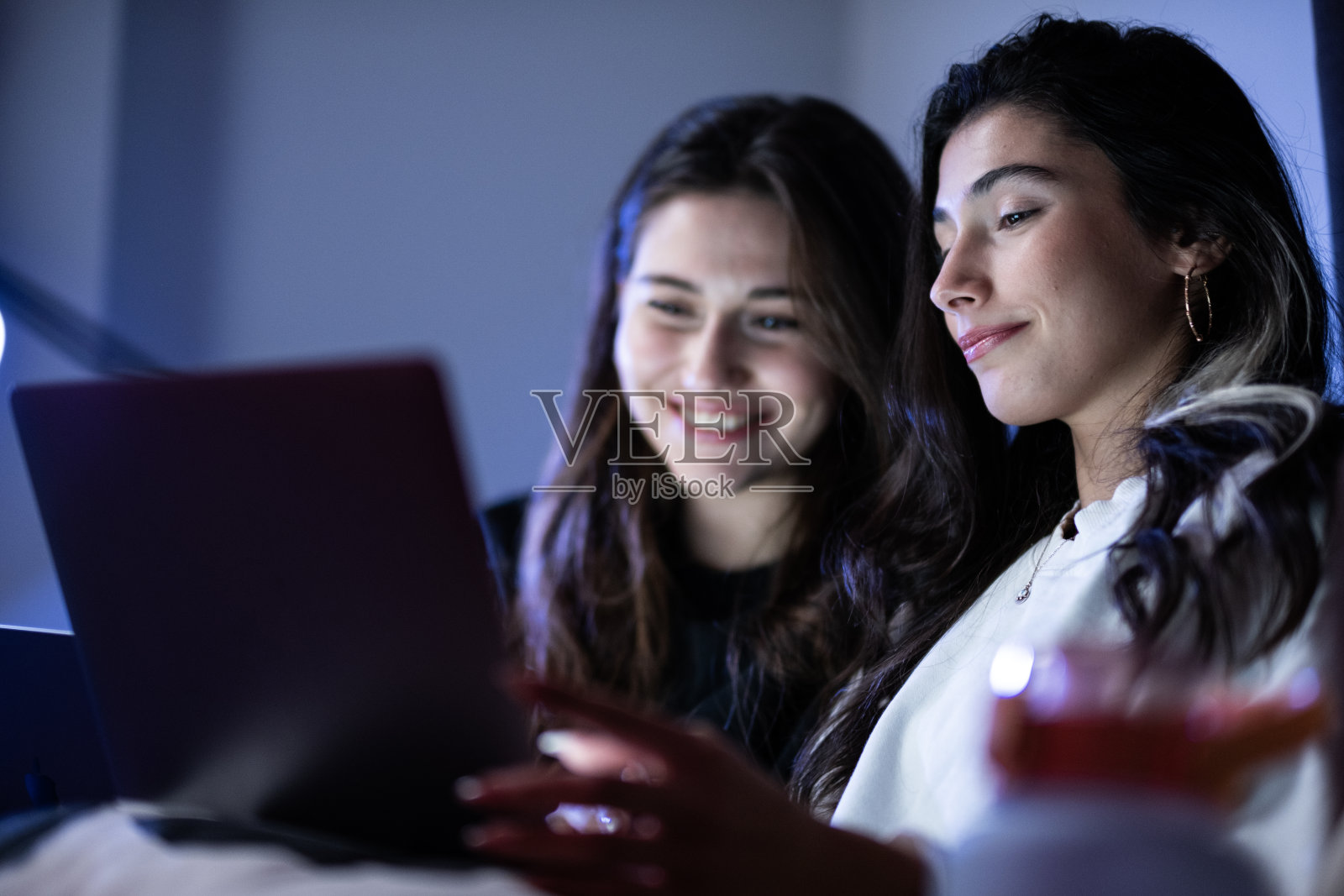 两个十几岁的女孩看着笔记本电脑屏幕照片摄影图片