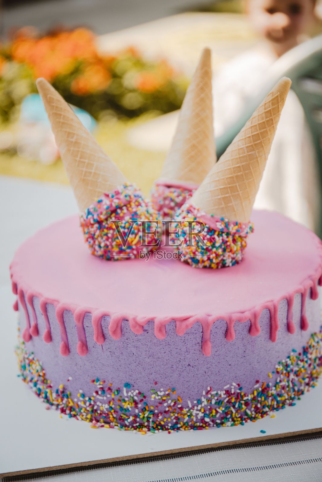 粉色和紫色的滴状蛋糕，上面有华夫蛋筒，垂直拍摄照片摄影图片