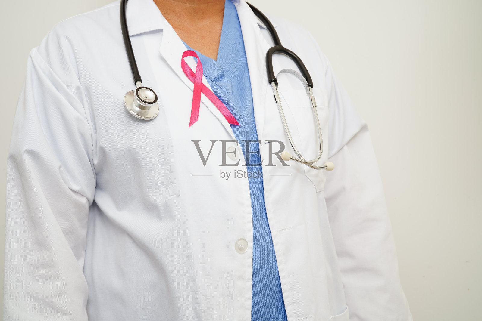 10月世界乳腺癌日，佩戴粉红丝带的亚洲女医生。照片摄影图片