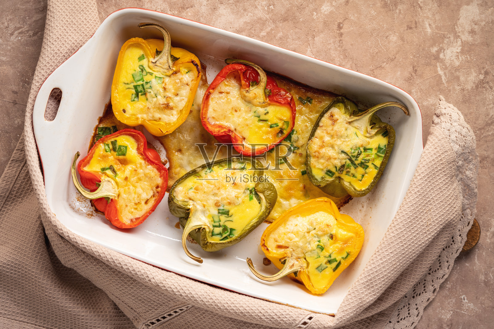 生酮饮食——用鸡蛋、奶酪和培根填充胡椒，在烤箱中烘焙。照片摄影图片
