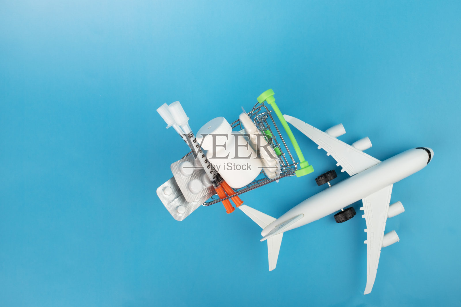 药片运输，药房推车与药片和飞机在蓝色背景，复制空间照片摄影图片