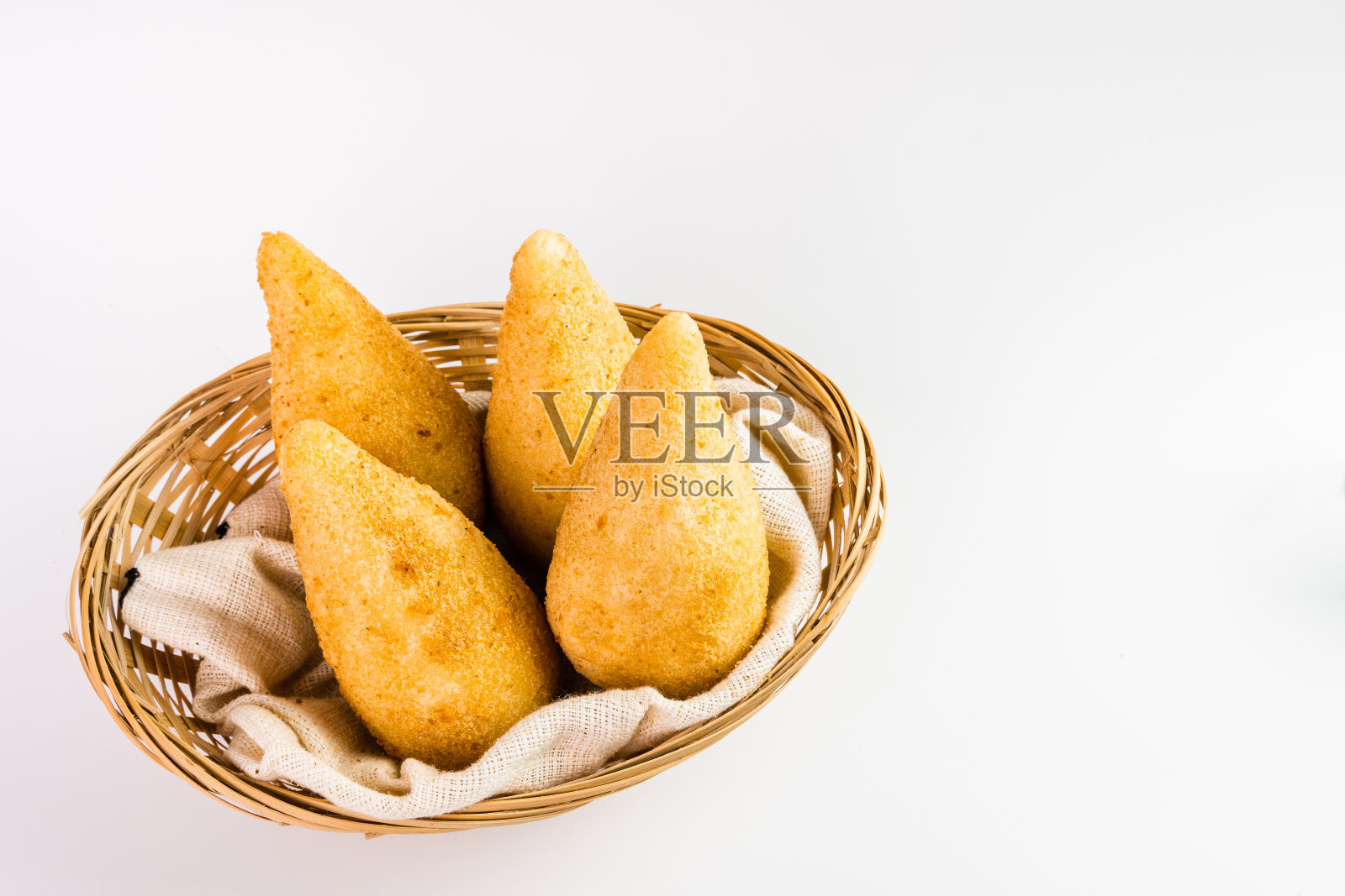 传统小吃，Coxinha鸡，在巴西被称为Coxinha。装在篮子里。白色背景。有选择性的重点照片摄影图片