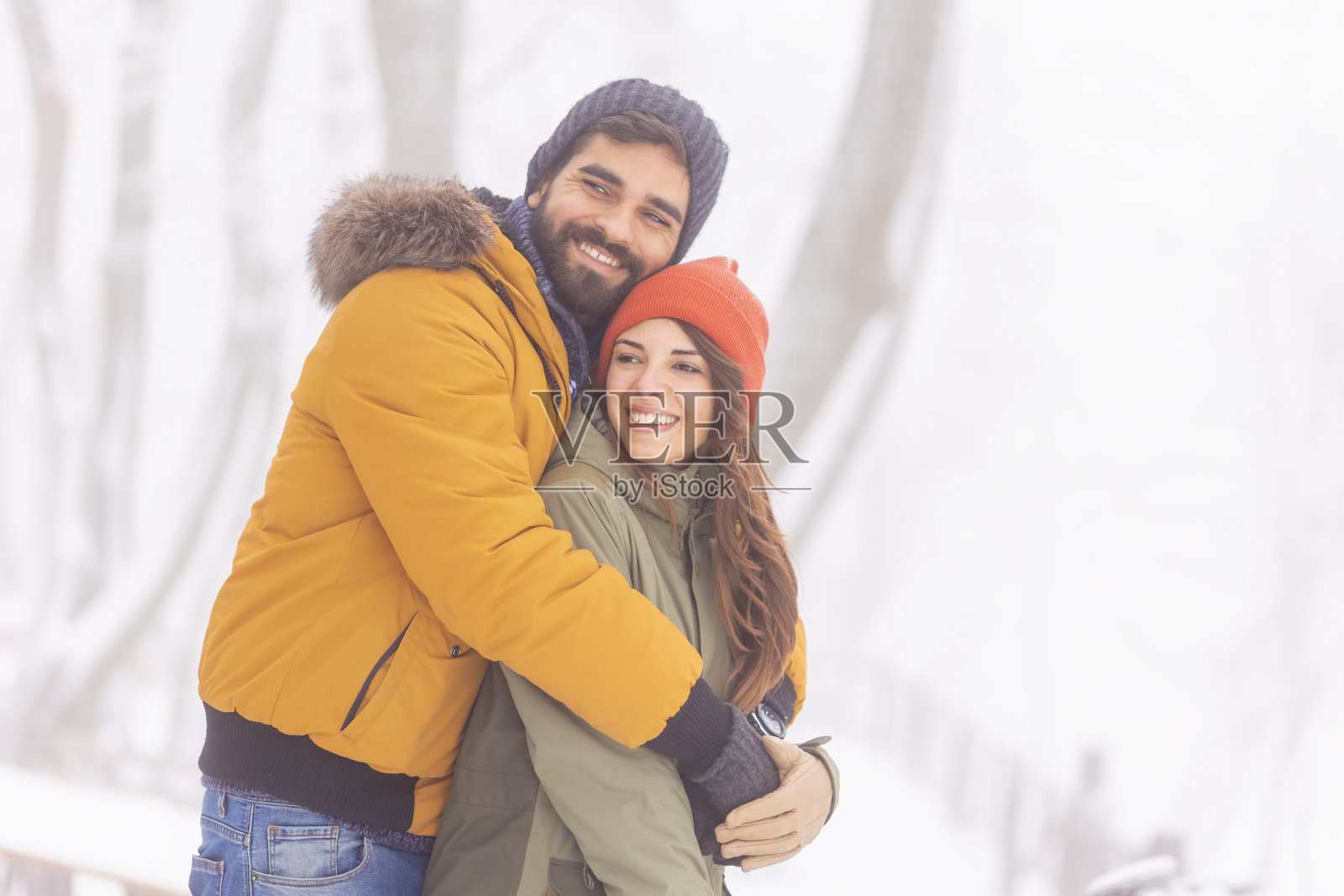 在雪地里拥抱的情侣照片摄影图片