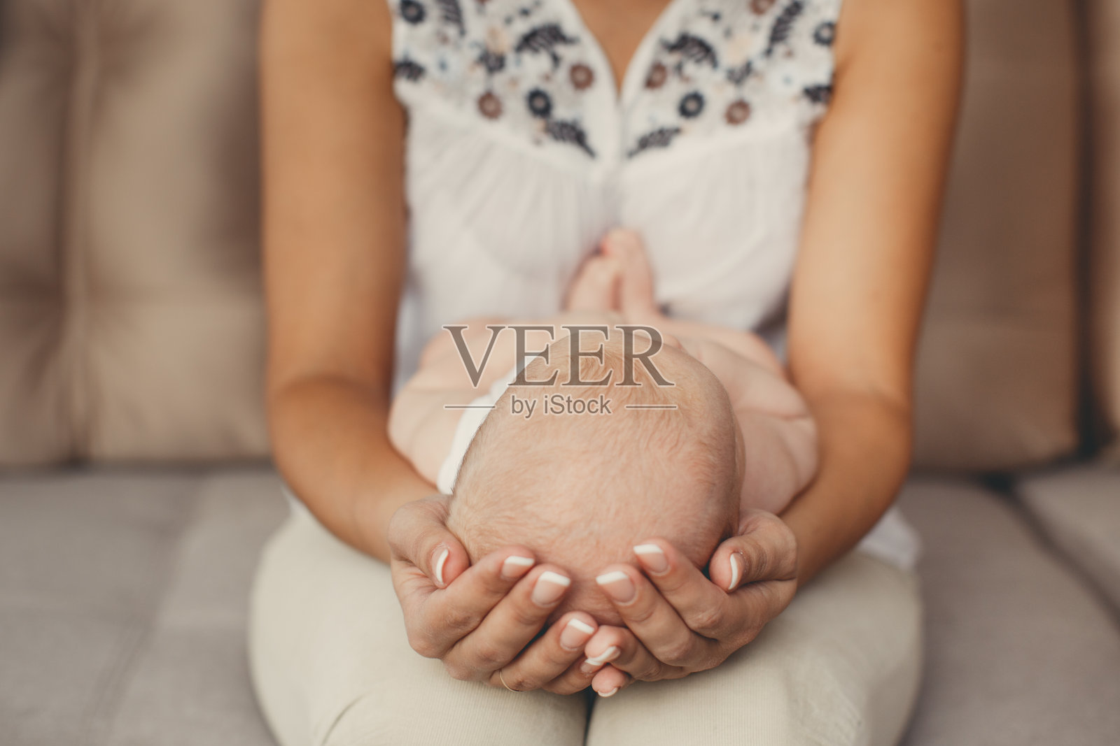 快乐的年轻母亲和刚出生的儿子在明亮的卧室里玩耍。照片摄影图片