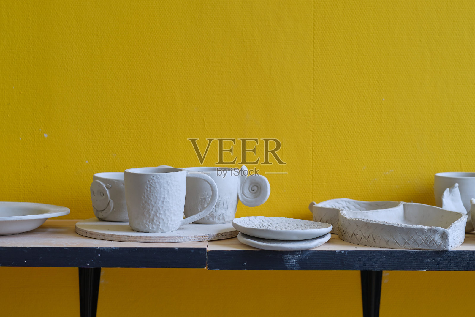 架子上未完成的陶罐是陶瓷作坊的一部分。创意工作室陶工。不同的陶瓷餐具放在木架子上。照片摄影图片