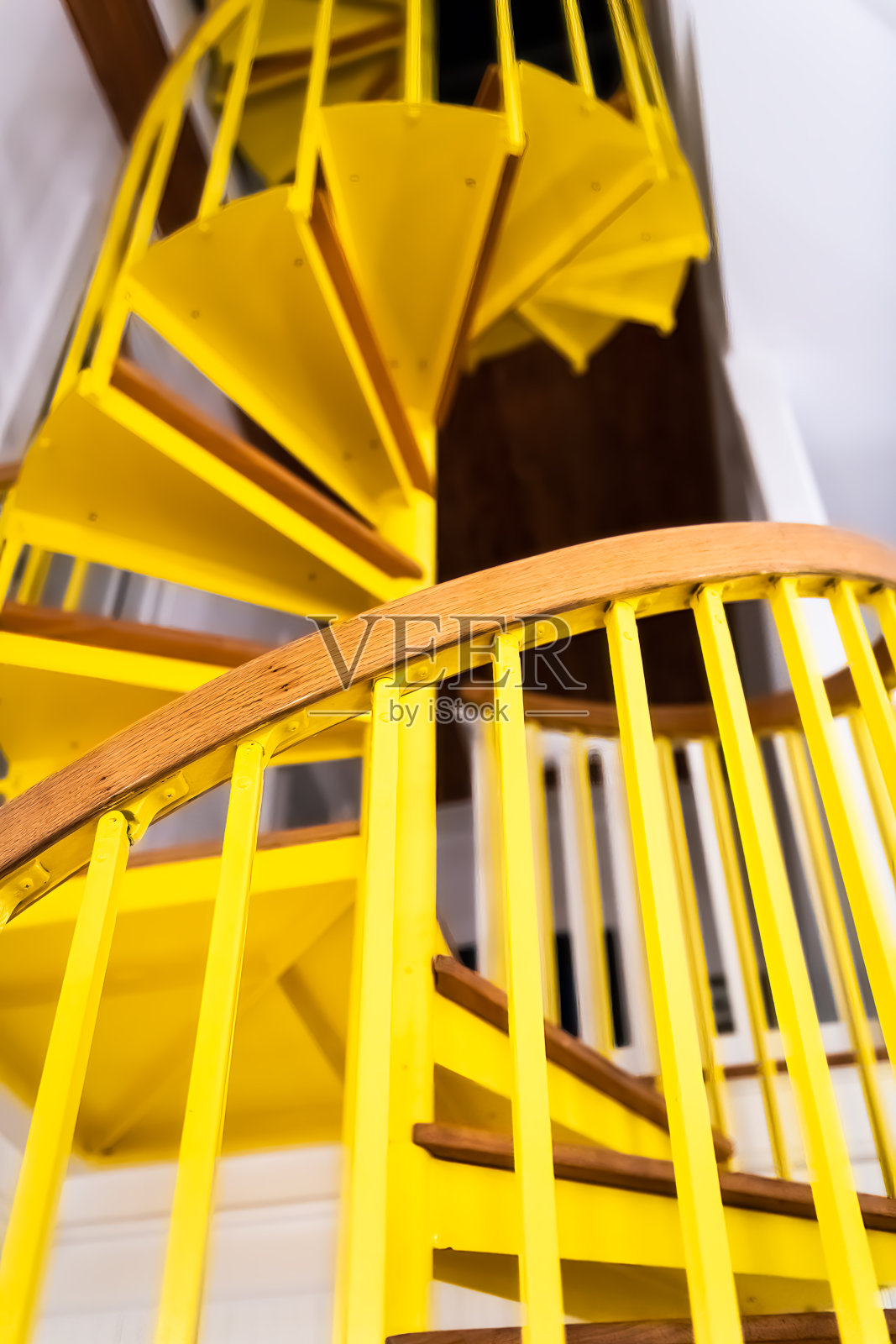 下面向上看的视角的老旧的楼梯在家庭内部与黄色的木制螺旋图案建筑照片摄影图片