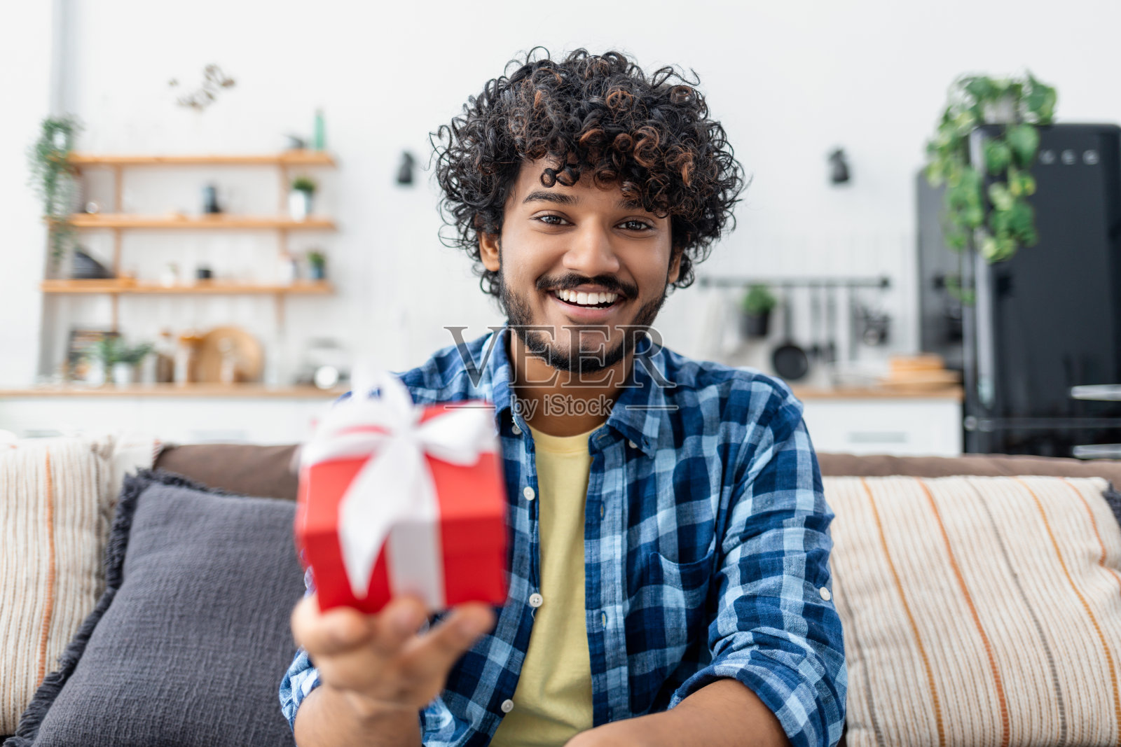 快乐的男人送礼物。周年纪念日，情人节或生日在线概念。年轻的亚洲人用网络摄像头祝贺爱人照片摄影图片