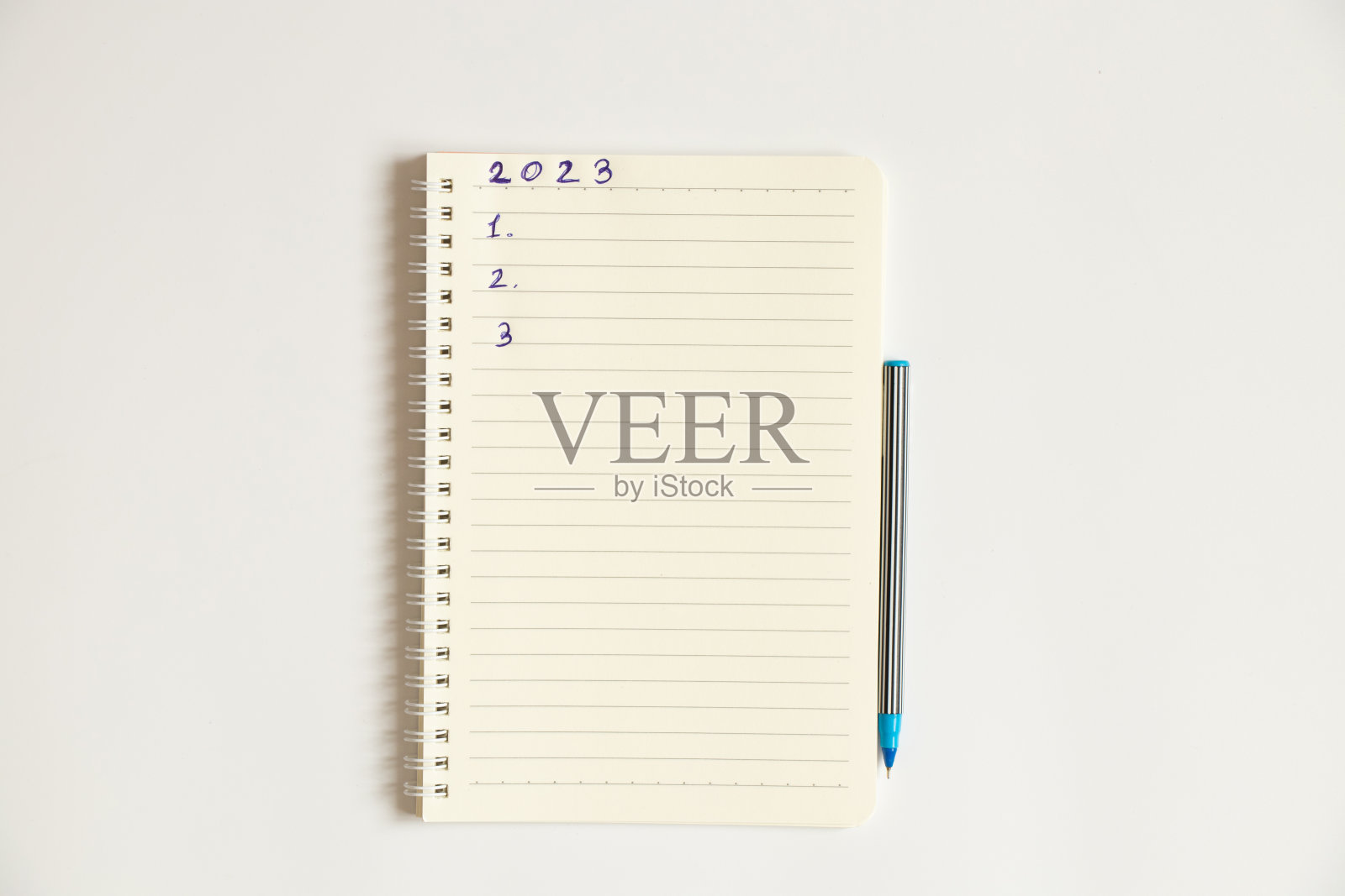 白色的记事本，白底文字2023，编号123，一支笔，一张设计图照片摄影图片