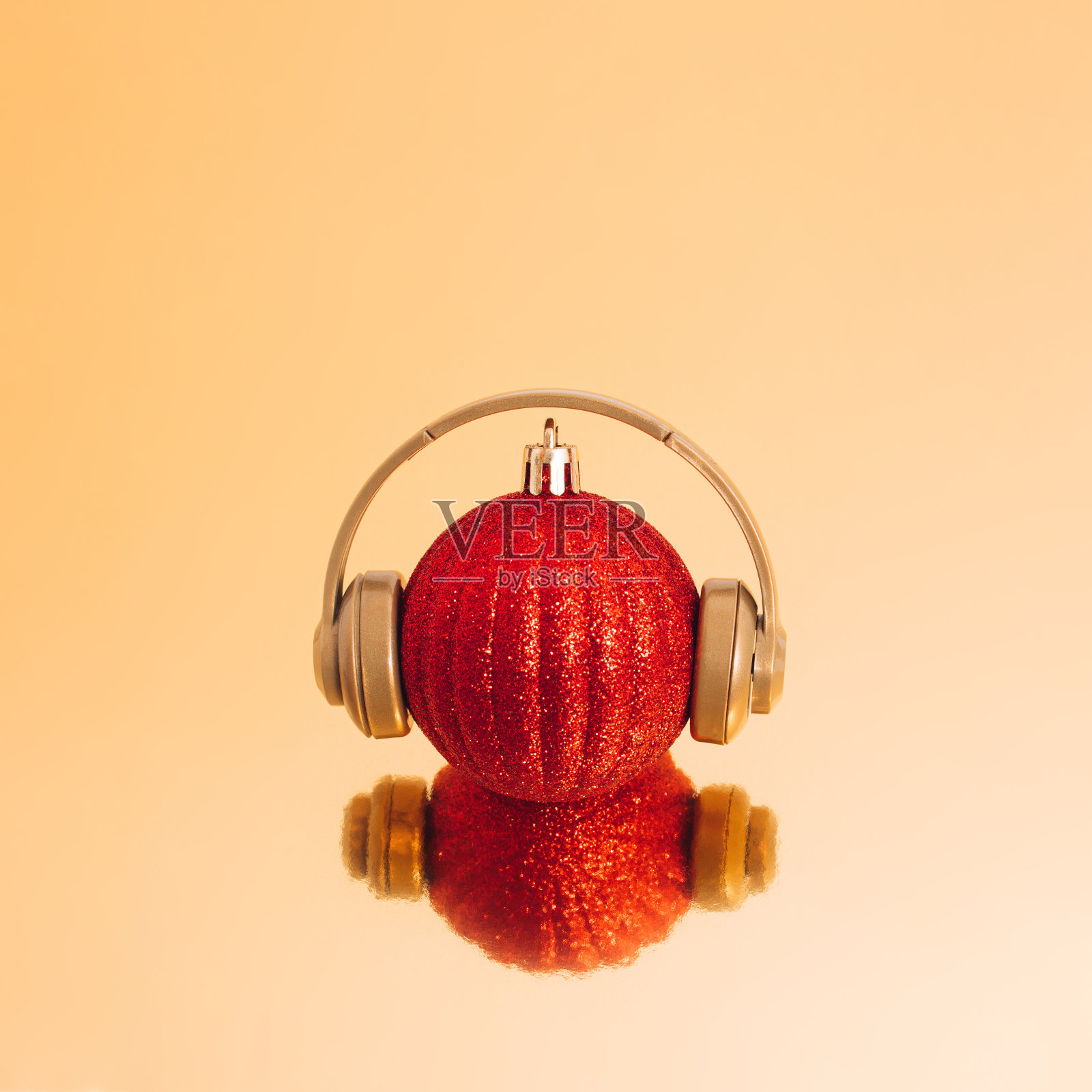 红色圣诞小玩意和背景反射耳机圣诞，新年和寒假的音乐，歌曲和幸福的概念。照片摄影图片