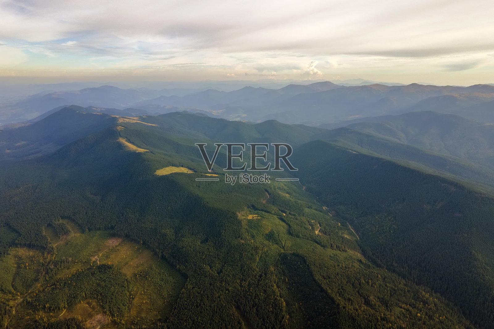 鸟瞰明亮雾蒙蒙的早晨在黑暗的小山与山林树木在秋天日出。黎明时分的野生林地美景照片摄影图片