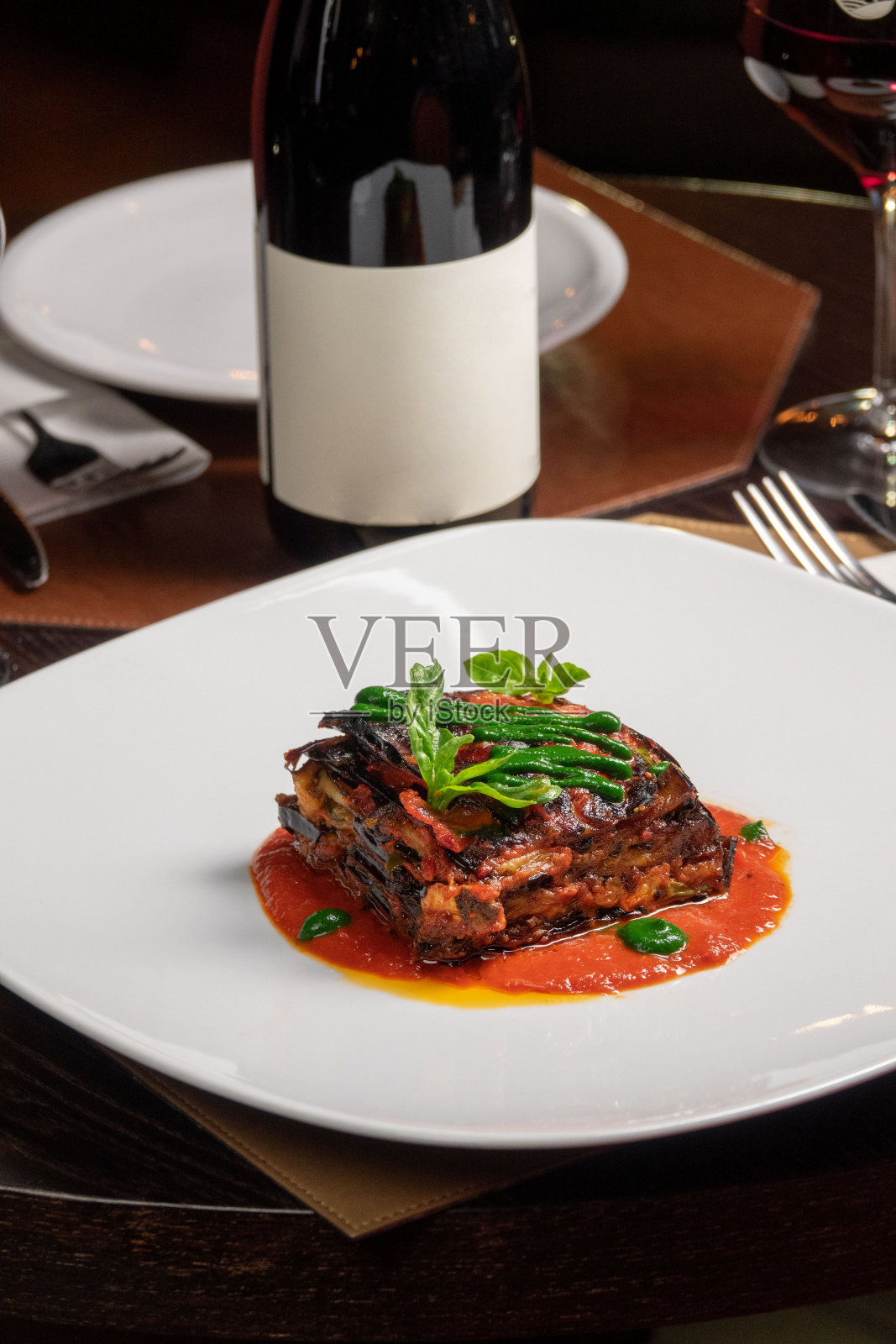 意大利茄子帕尔马干酪配酒杯和一瓶葡萄酒照片摄影图片