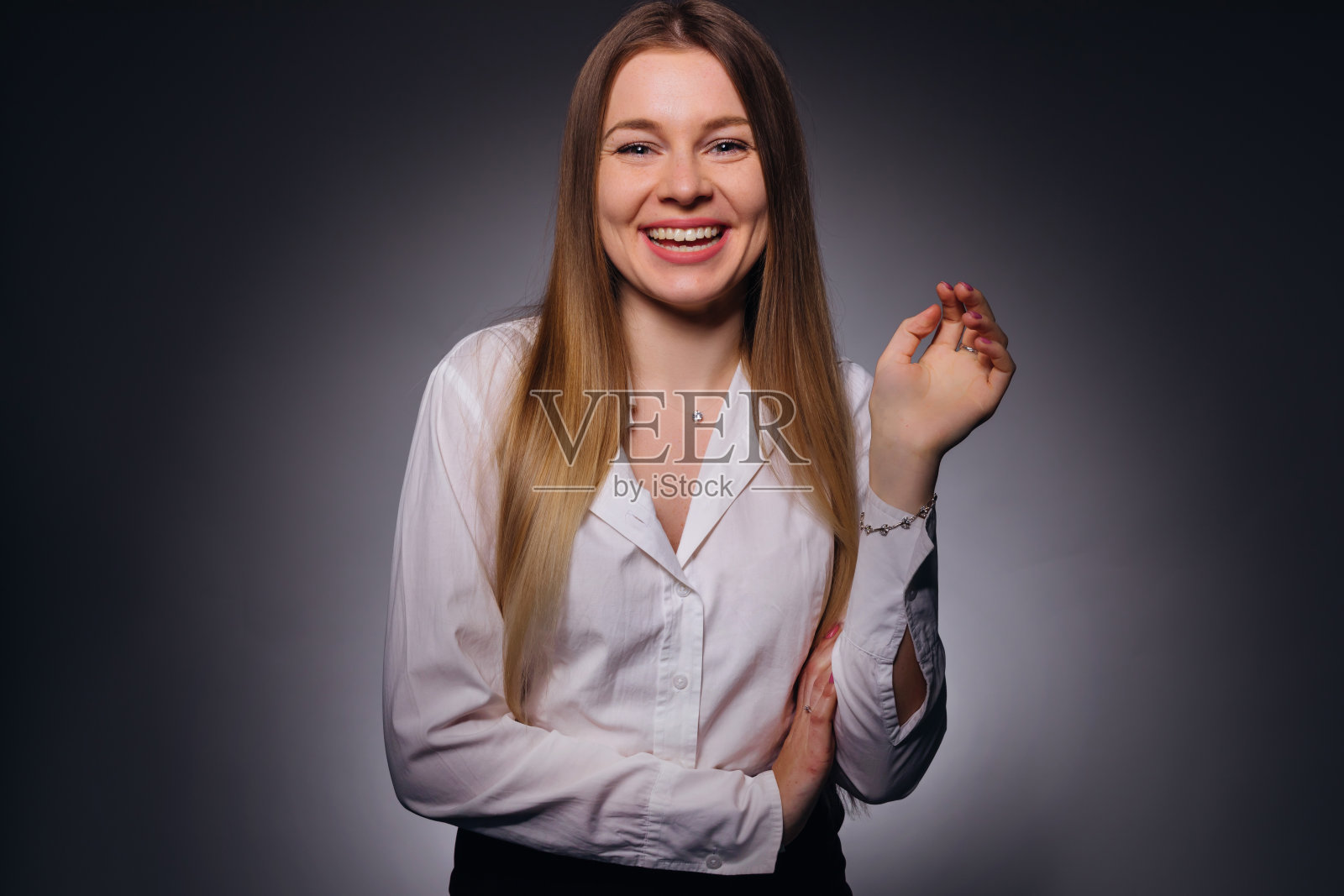 一个年轻女子的肖像，穿着白色的衬衫，面带美丽的微笑照片摄影图片