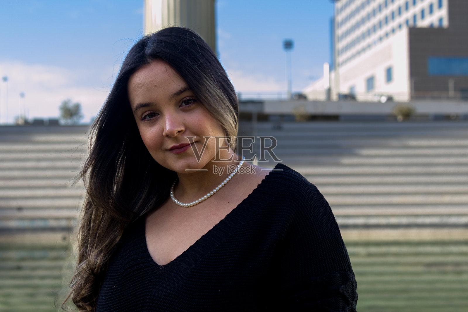 一位美丽的哥伦比亚妇女站在圆形剧场，看着摄像机照片摄影图片