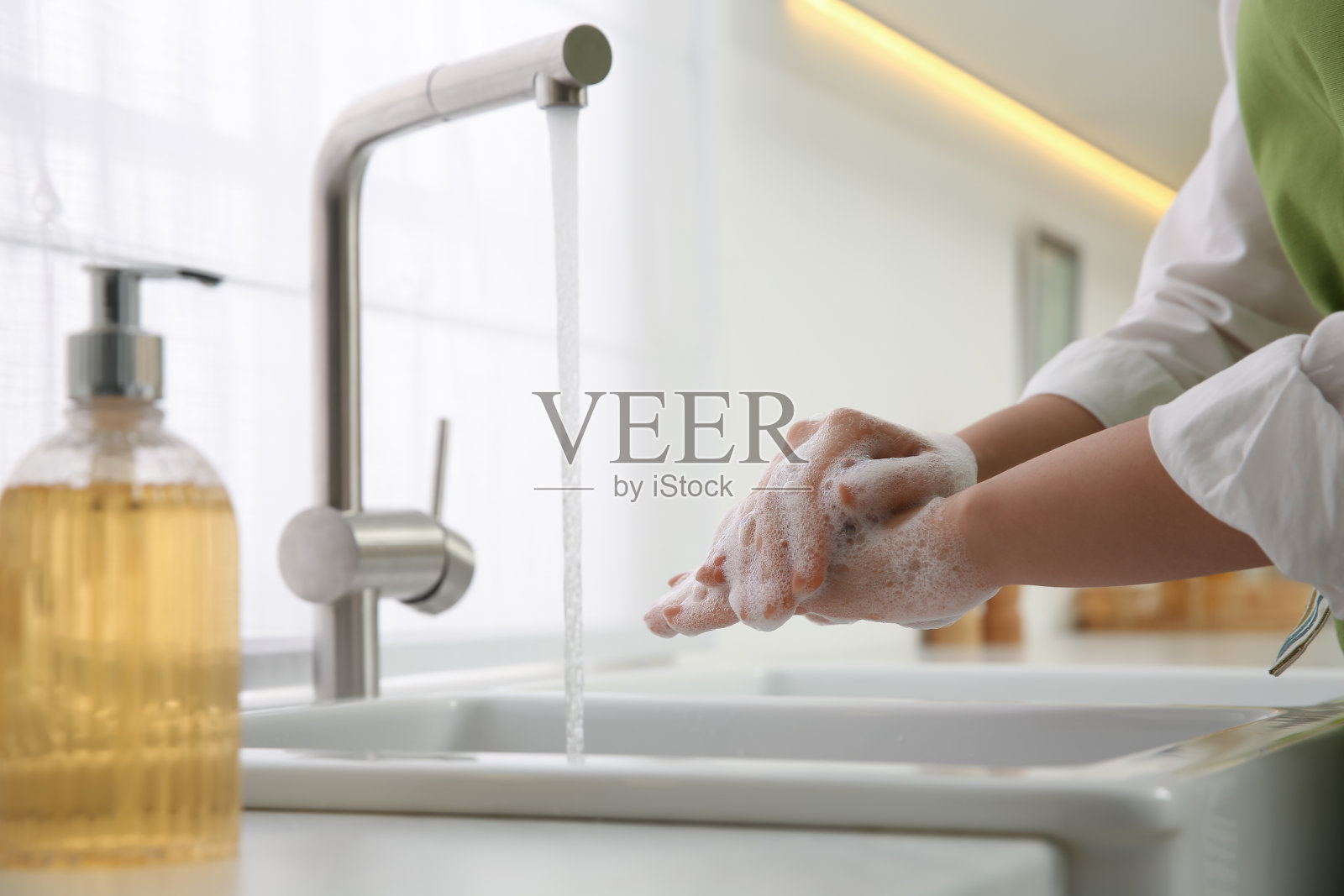 妇女在厨房用肥皂洗手，特写照片摄影图片