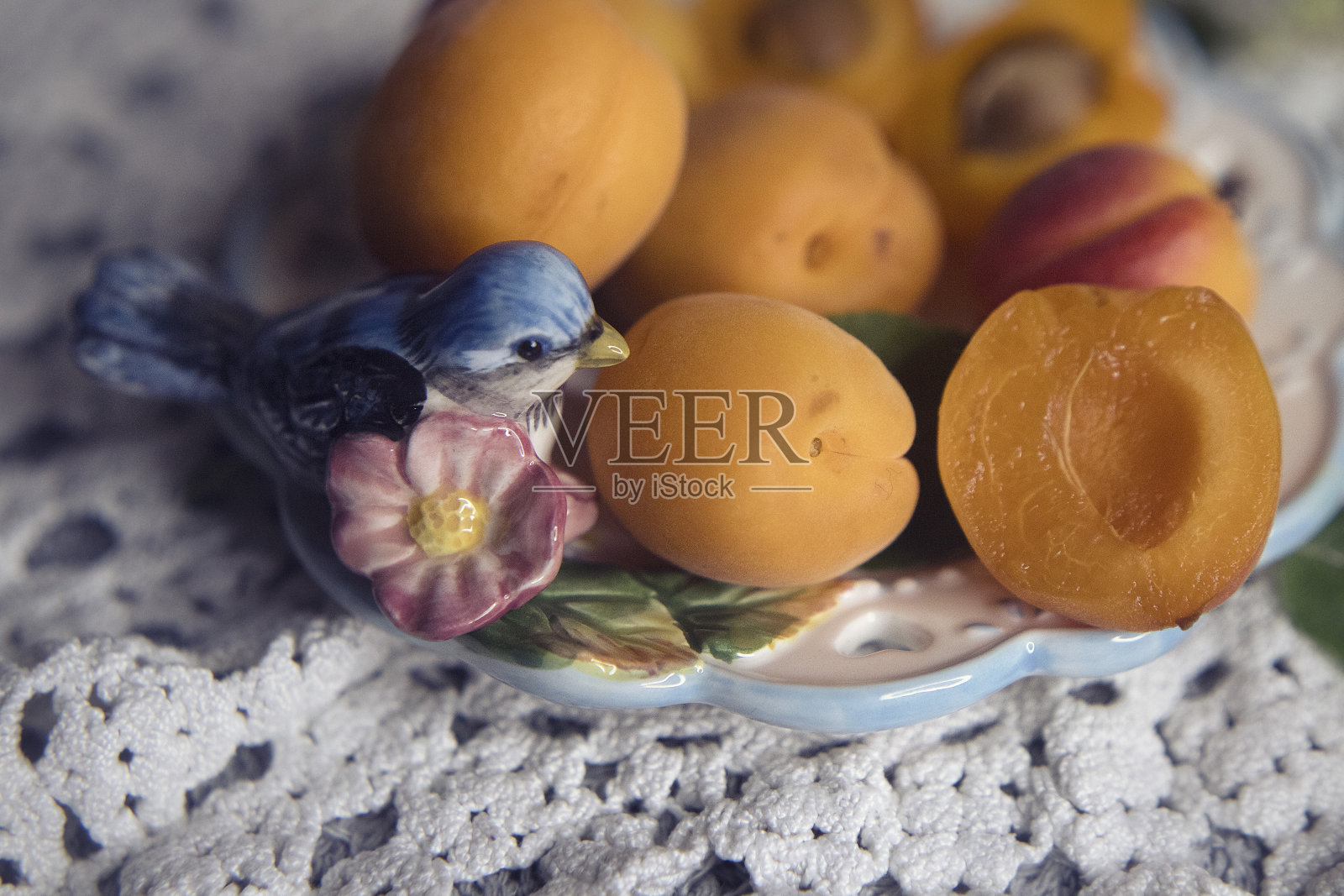 杏子和一只鸟放在盘子里照片摄影图片