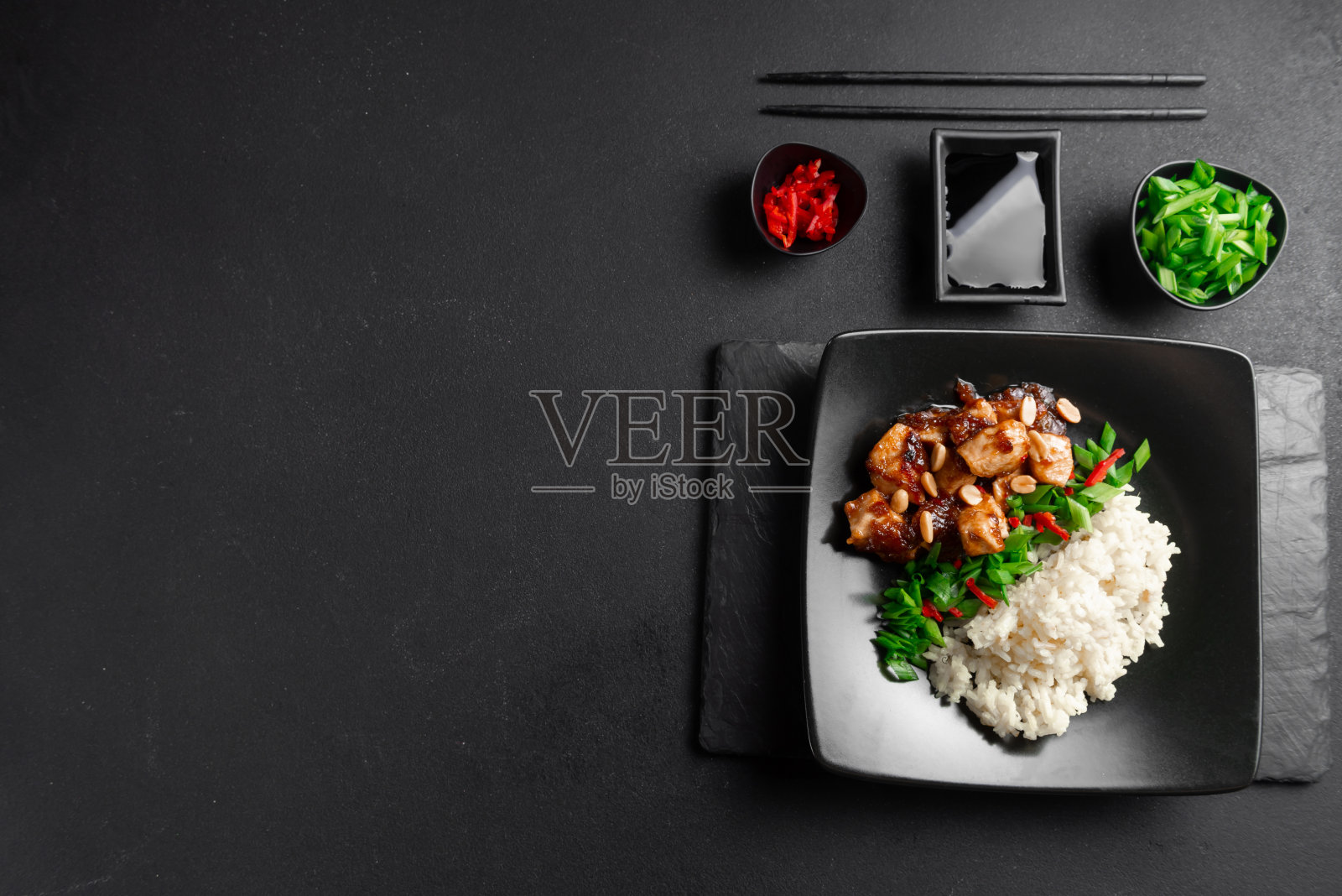 亚洲美食。深色背景俯视图上的鸡肉米饭。水煮米饭配炒鸡胸肉片和罗勒。泰国菜照片摄影图片