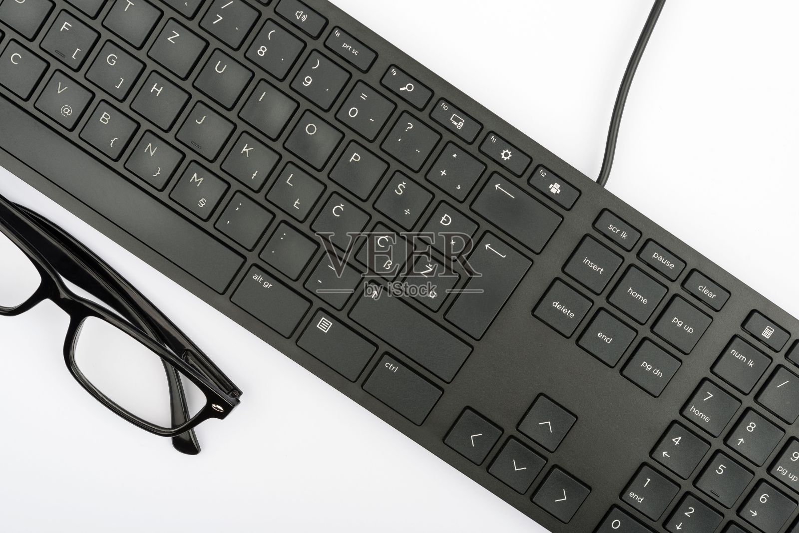 部分黑色电脑键盘和眼镜孤立在白色背景上照片摄影图片