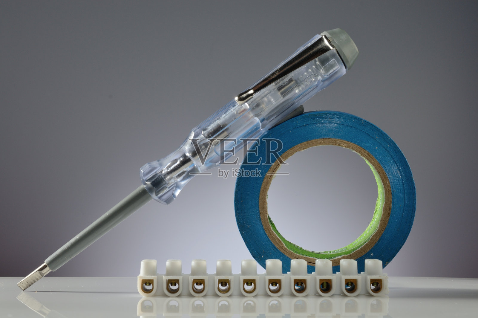 电工用工具的组成。灰色渐变背景。特写镜头。照片摄影图片