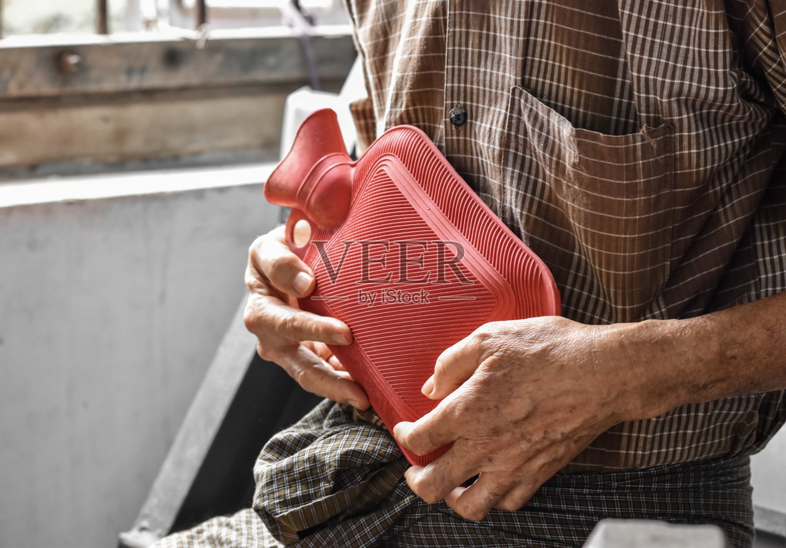 亚洲男子腹痛。引起胃痛、肠炎、结肠炎、阑尾炎、肝炎、胰腺炎、食物中毒等。用橡胶热水袋治疗。照片摄影图片