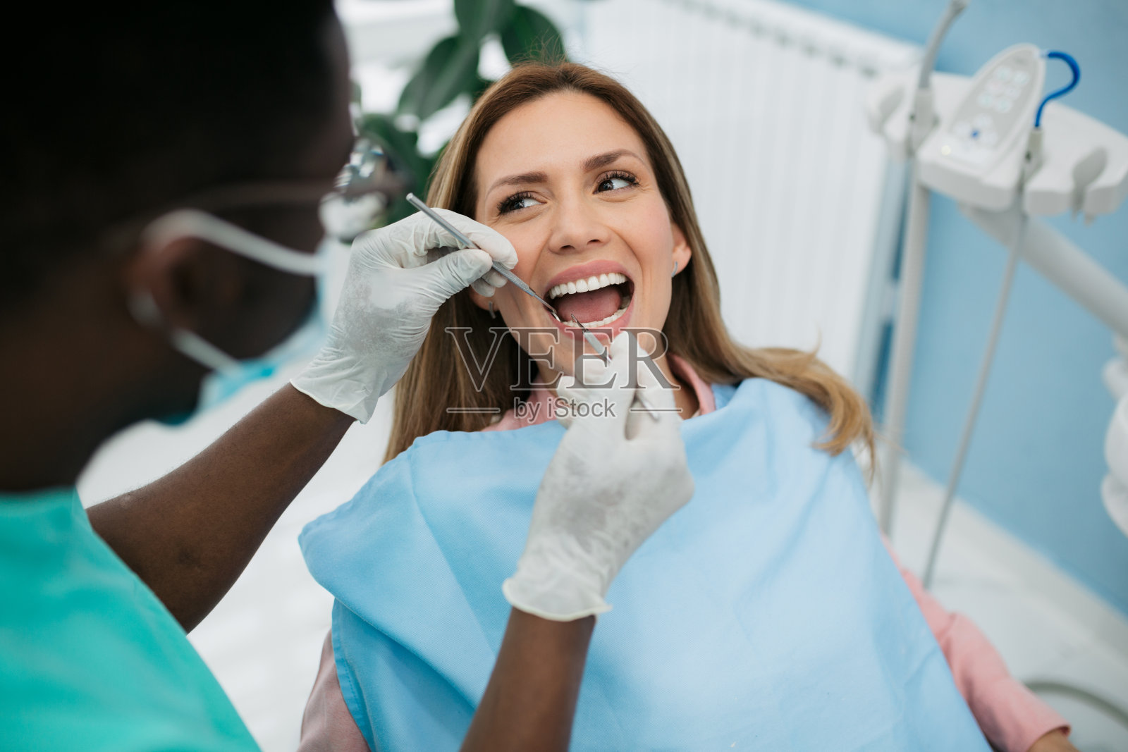 一位专业的牙医正在认真地照料他的女病人照片摄影图片