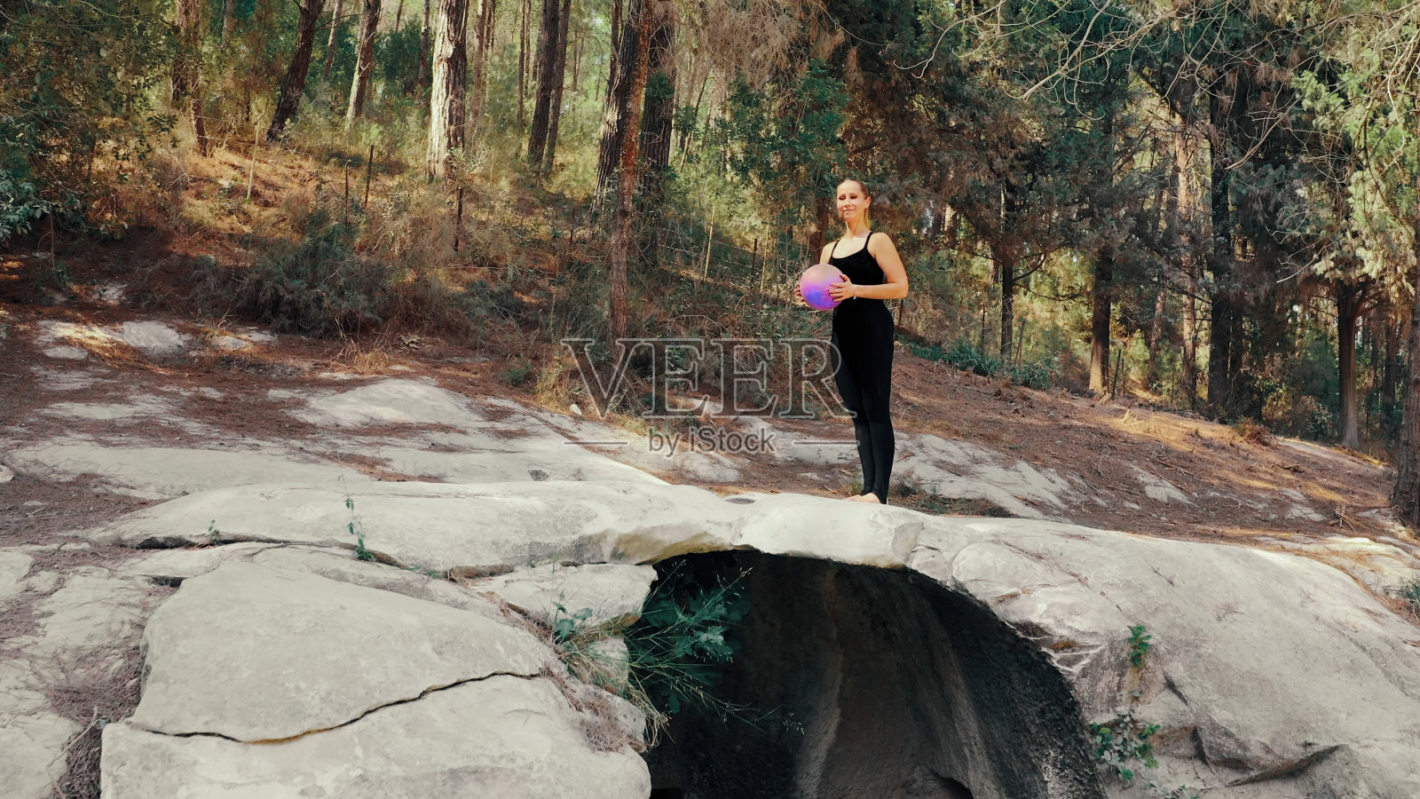 在公园的山顶上，一名女子正在用球做运动照片摄影图片