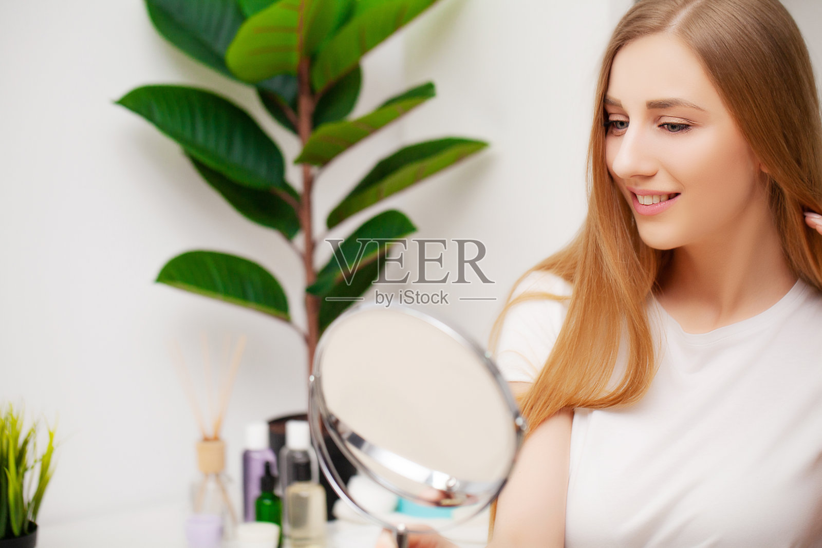 一个年轻漂亮的女人在洗澡后照镜子照片摄影图片