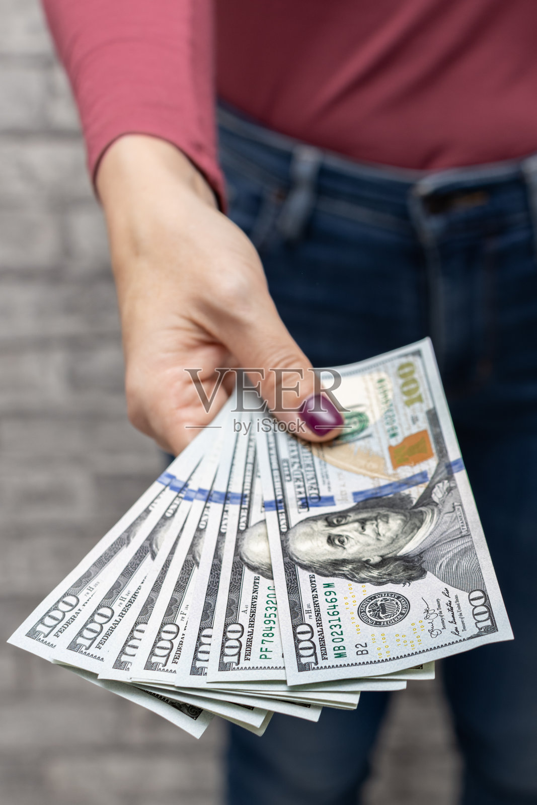 一个手里拿着一百美元的女人照片摄影图片