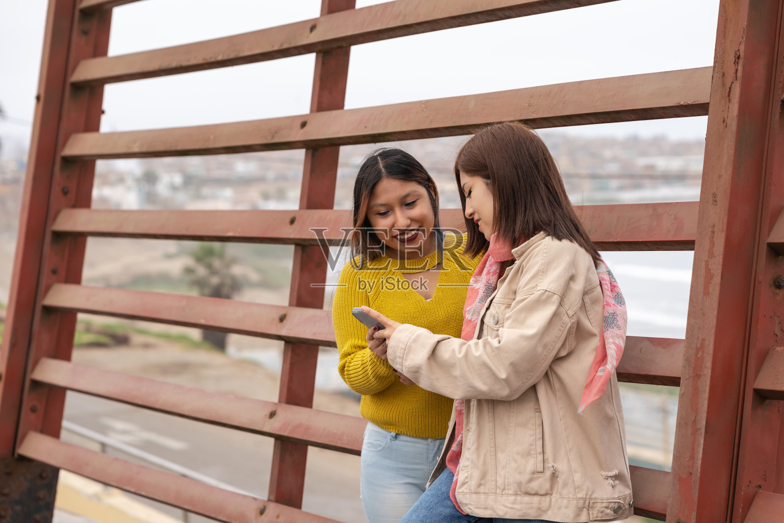两个朋友站在街上用手机照片摄影图片