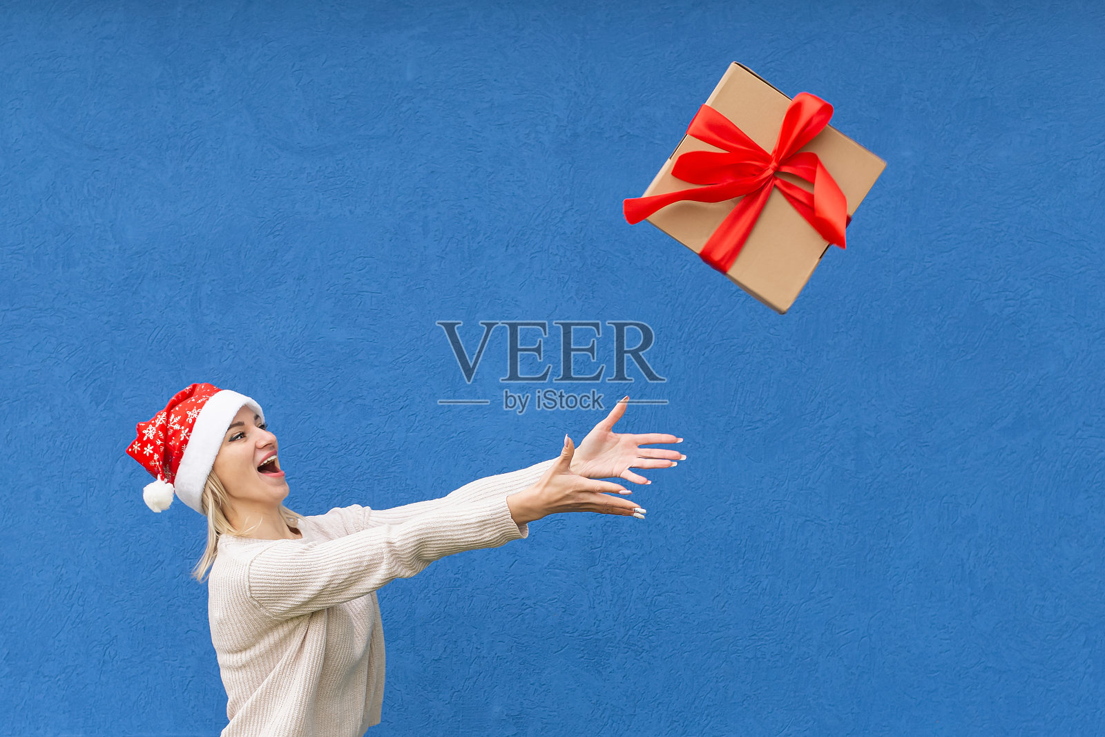 一个微笑的女人手里拿着一个礼品盒。节日和活动。圣诞节照片摄影图片