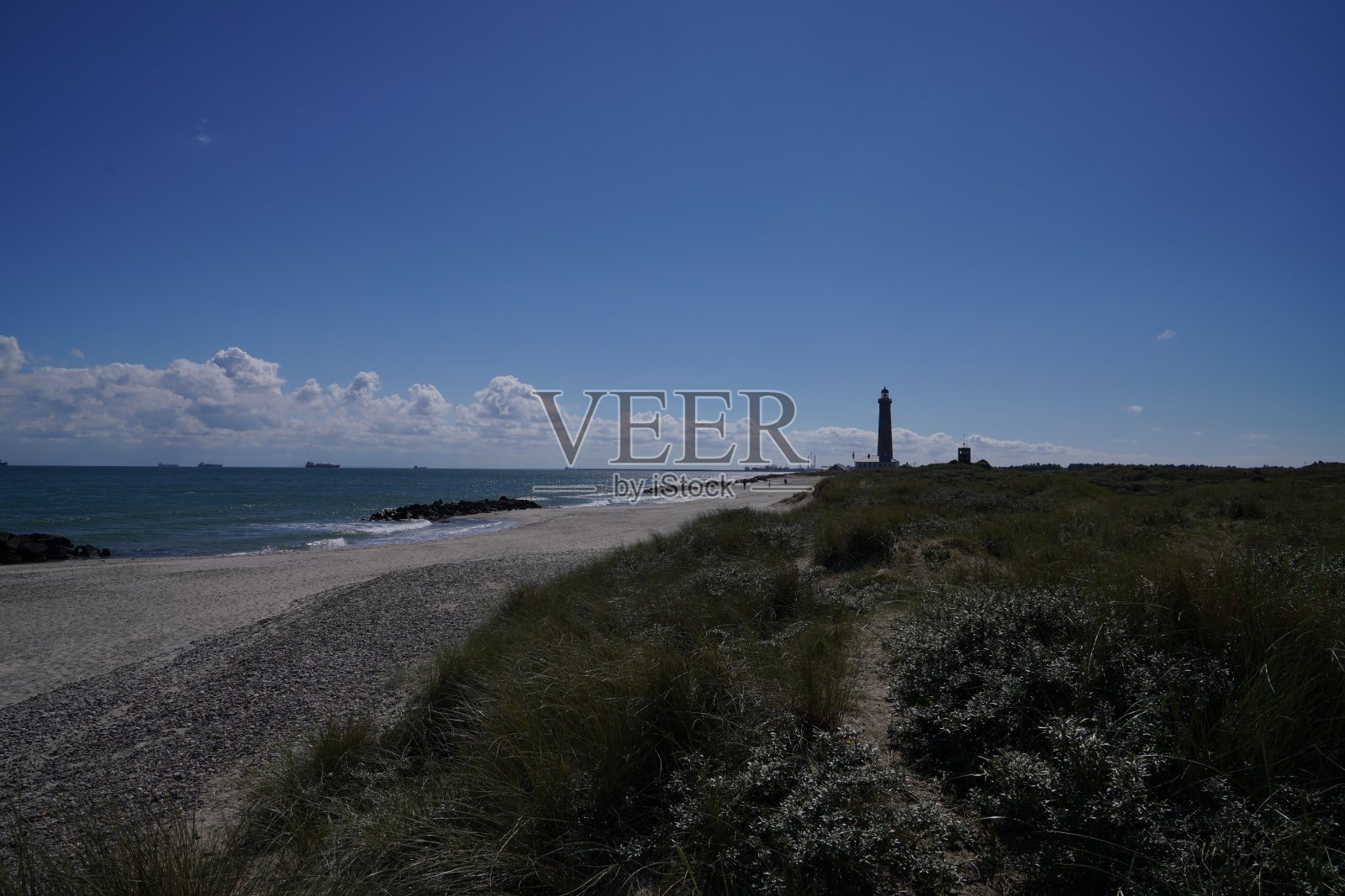 丹麦海岸，背景是灯塔照片摄影图片