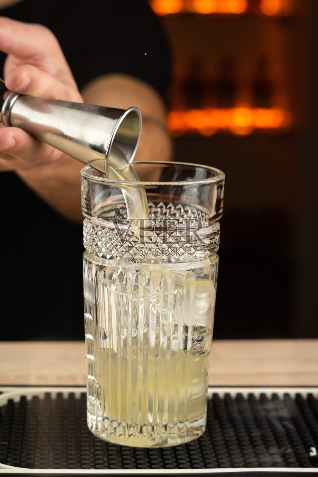 男酒保用跳汰机准备酒精鸡尾酒照片摄影图片