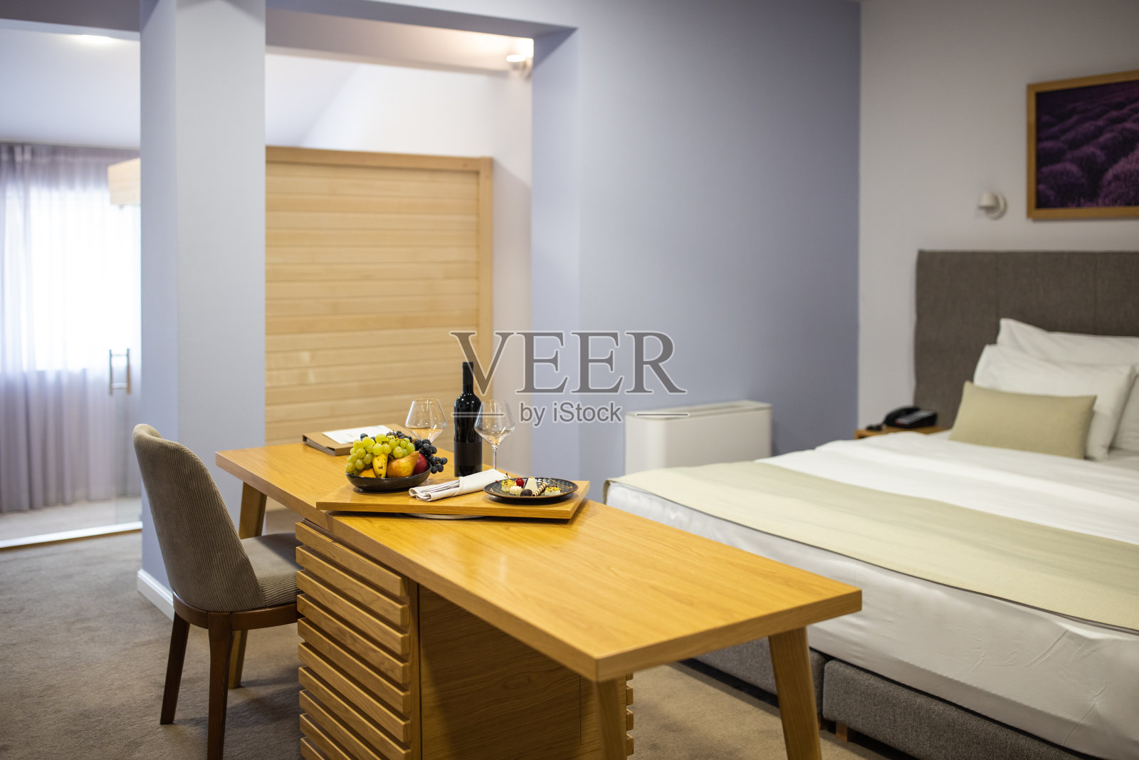 酒店套房有酒和水果碗在床头柜上照片摄影图片