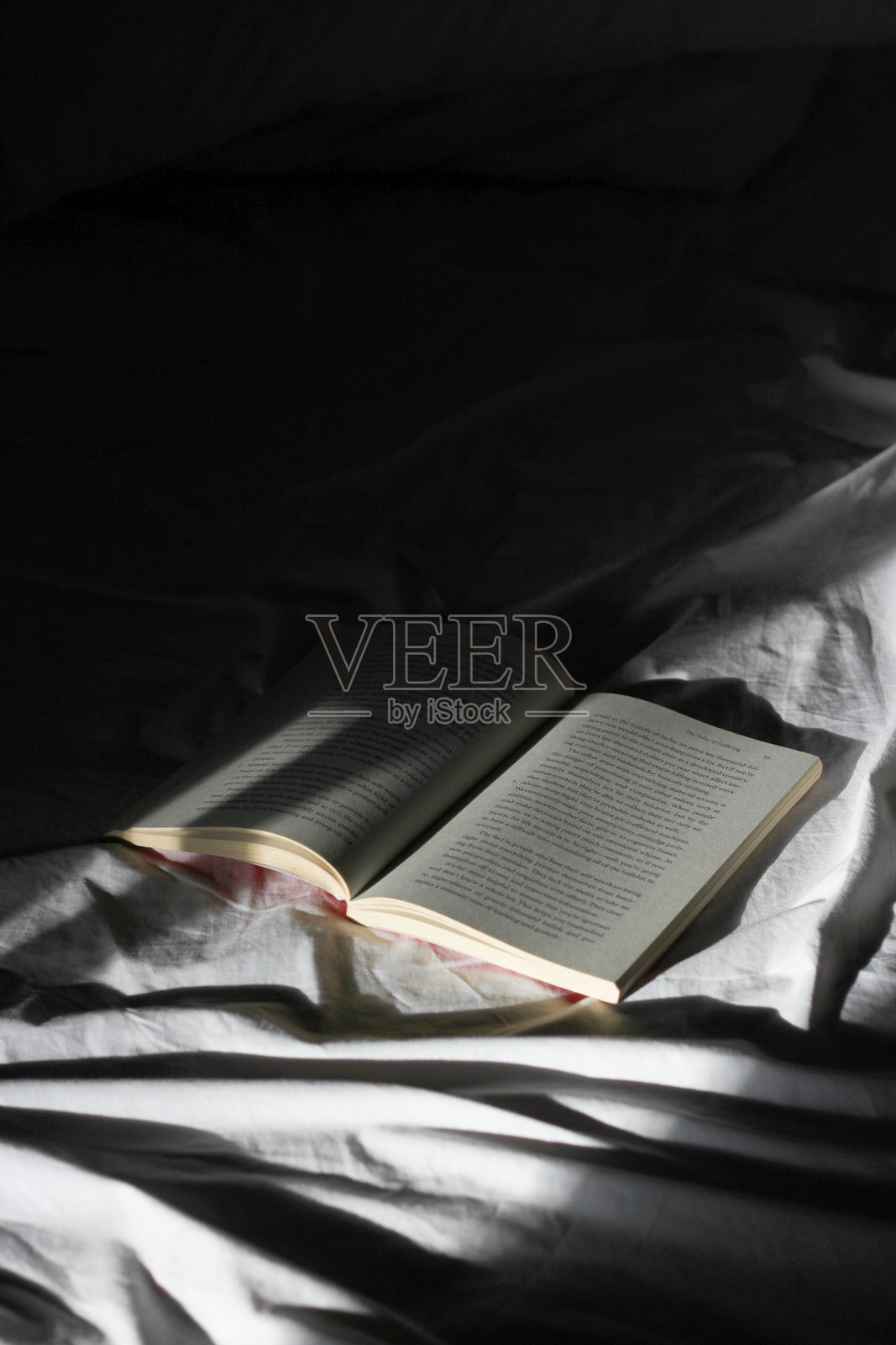在黑暗中在床上打开书照片摄影图片