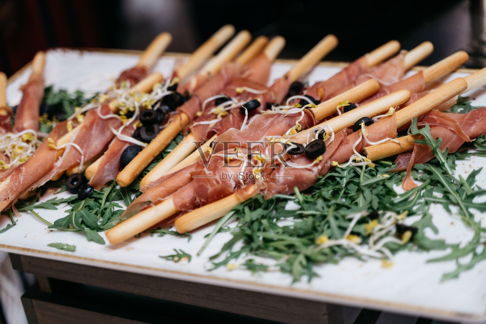 格里斯尼包着塞拉诺火腿，配以橄榄和芝麻菜照片摄影图片