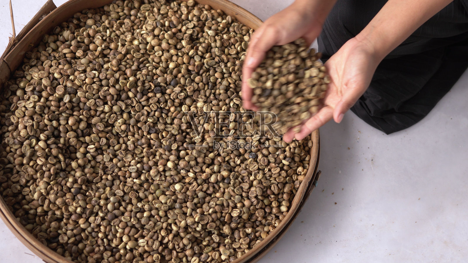 俯视图拍摄的男性手拿一些咖啡从咖啡豆木制容器照片摄影图片