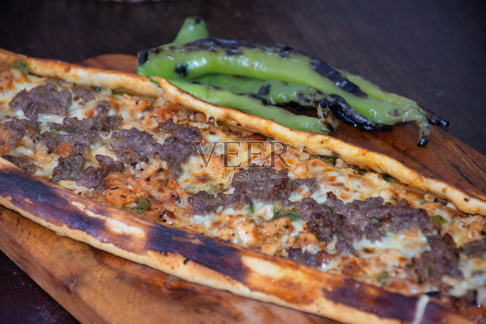 皮塔饼，也被称为土耳其披萨，是一种由烤肉串、烤鸡、切达奶酪、番茄和香料制成的面饼，照片摄影图片