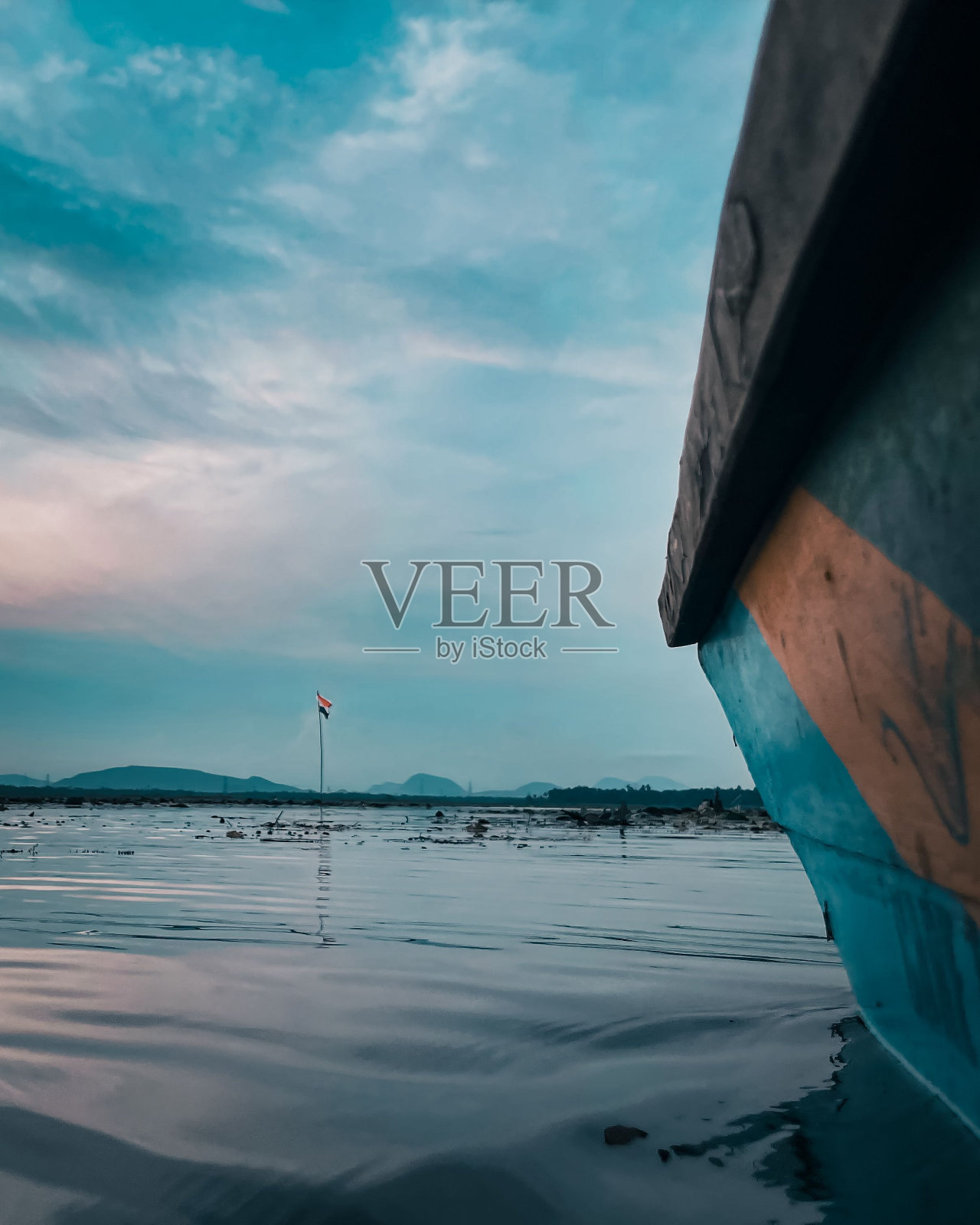 垂直镜头从旁边的一艘船的大海和印度国旗在另一边照片摄影图片