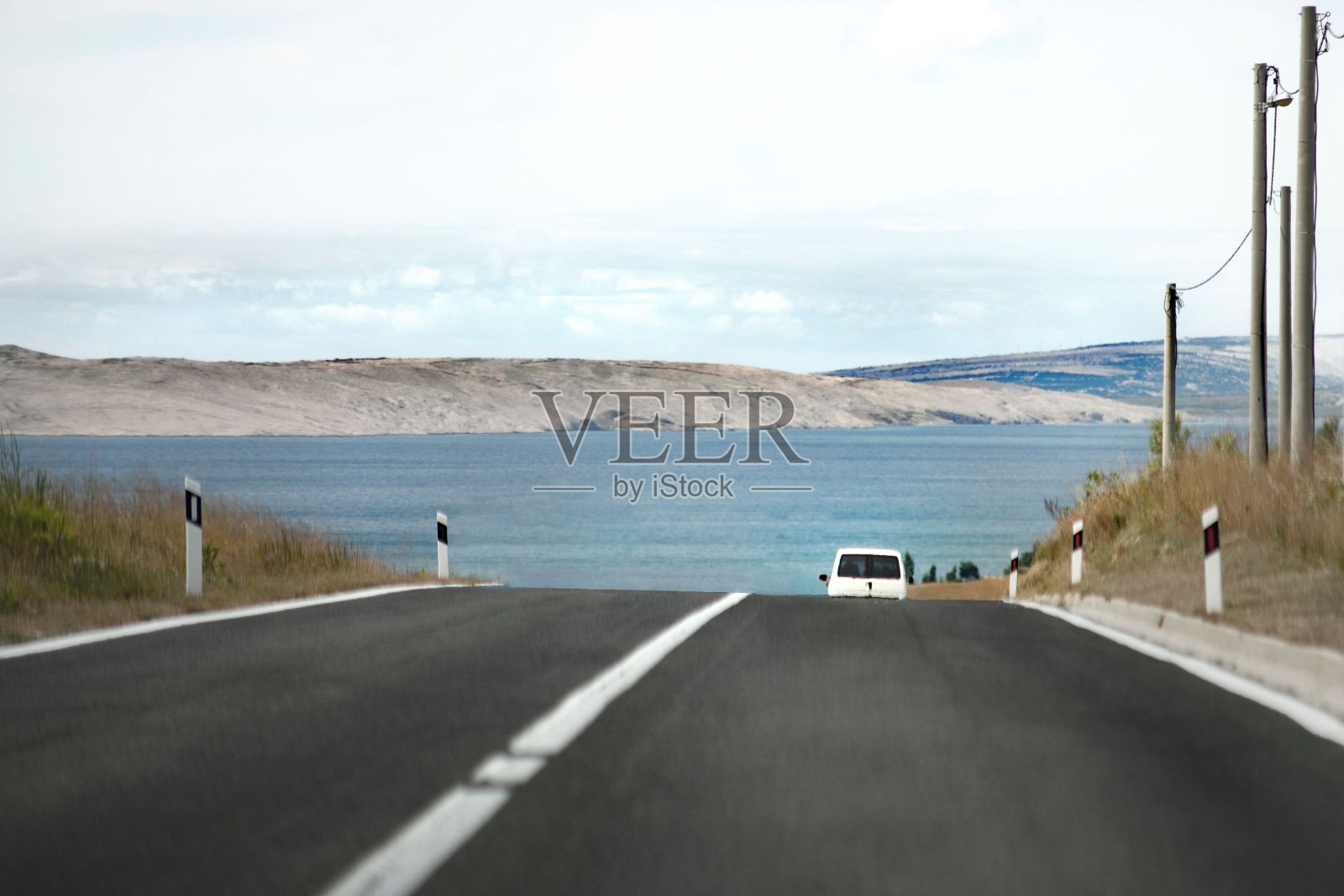 孤独的汽车行驶在湖光山色的道路上。照片摄影图片