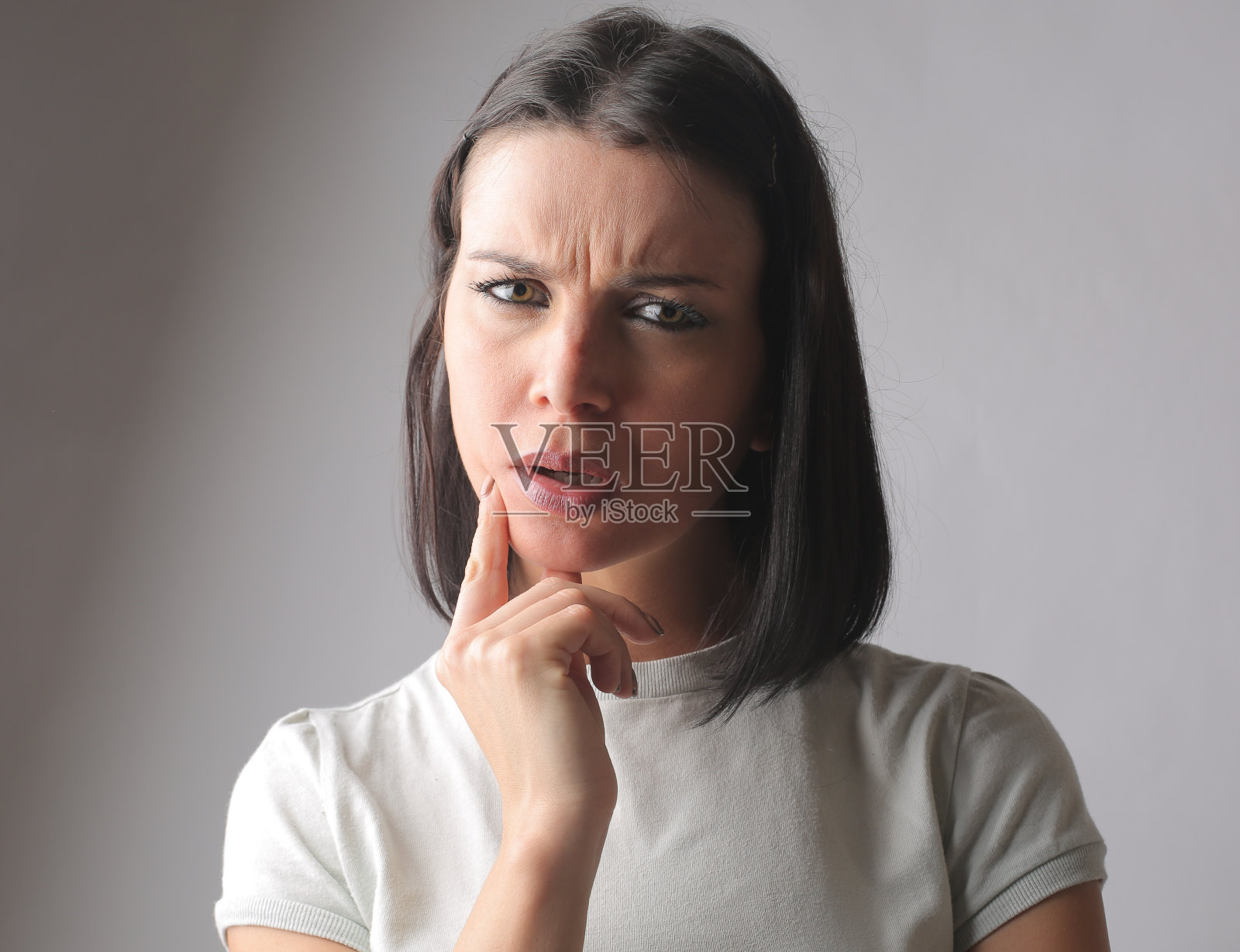 特写一个深思熟虑的匈牙利褐发女子看着相机，带着困惑、好奇的表情照片摄影图片