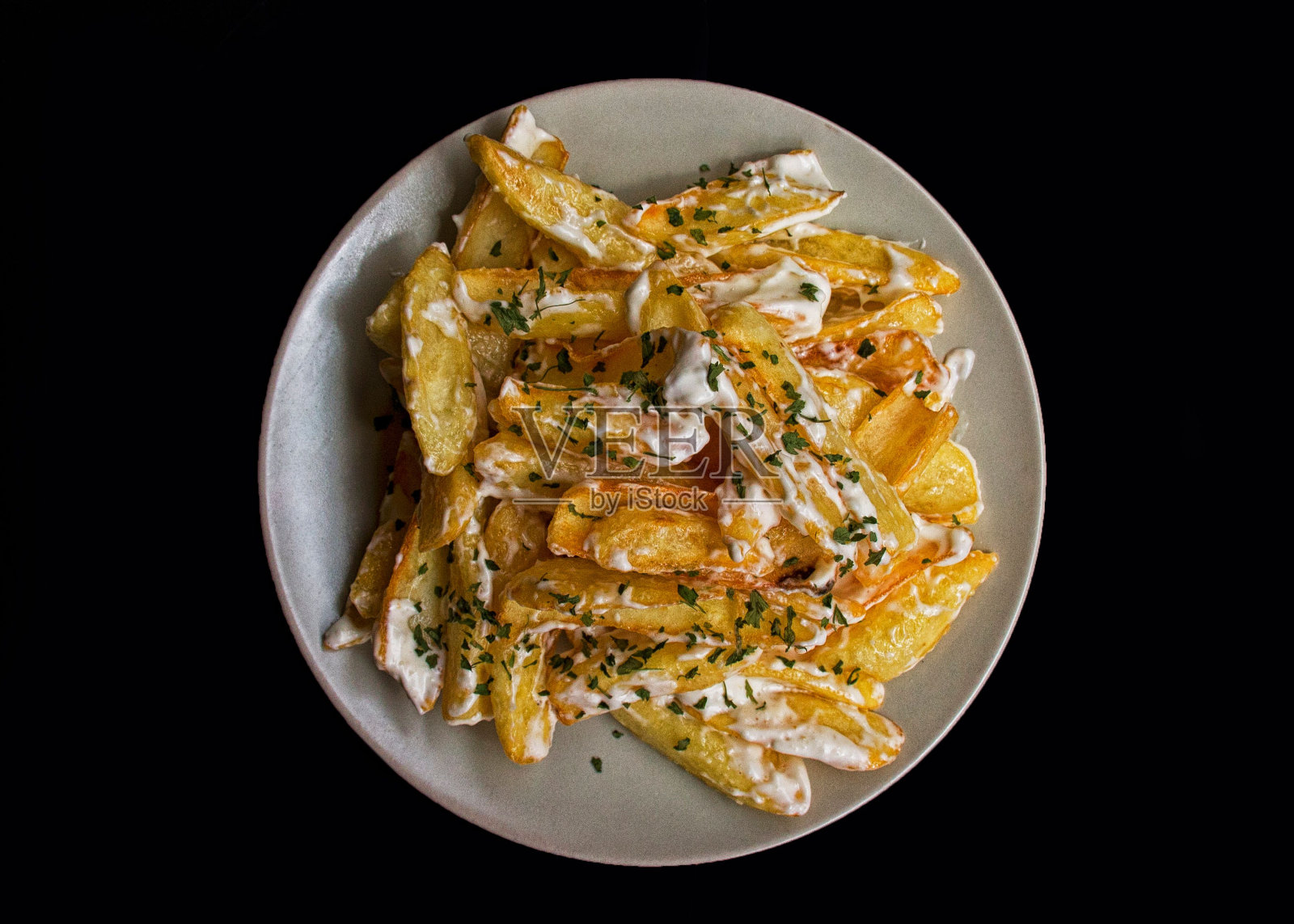 俯视图的土豆薯条，希腊薯条与酸奶油，奶酪和香草照片摄影图片