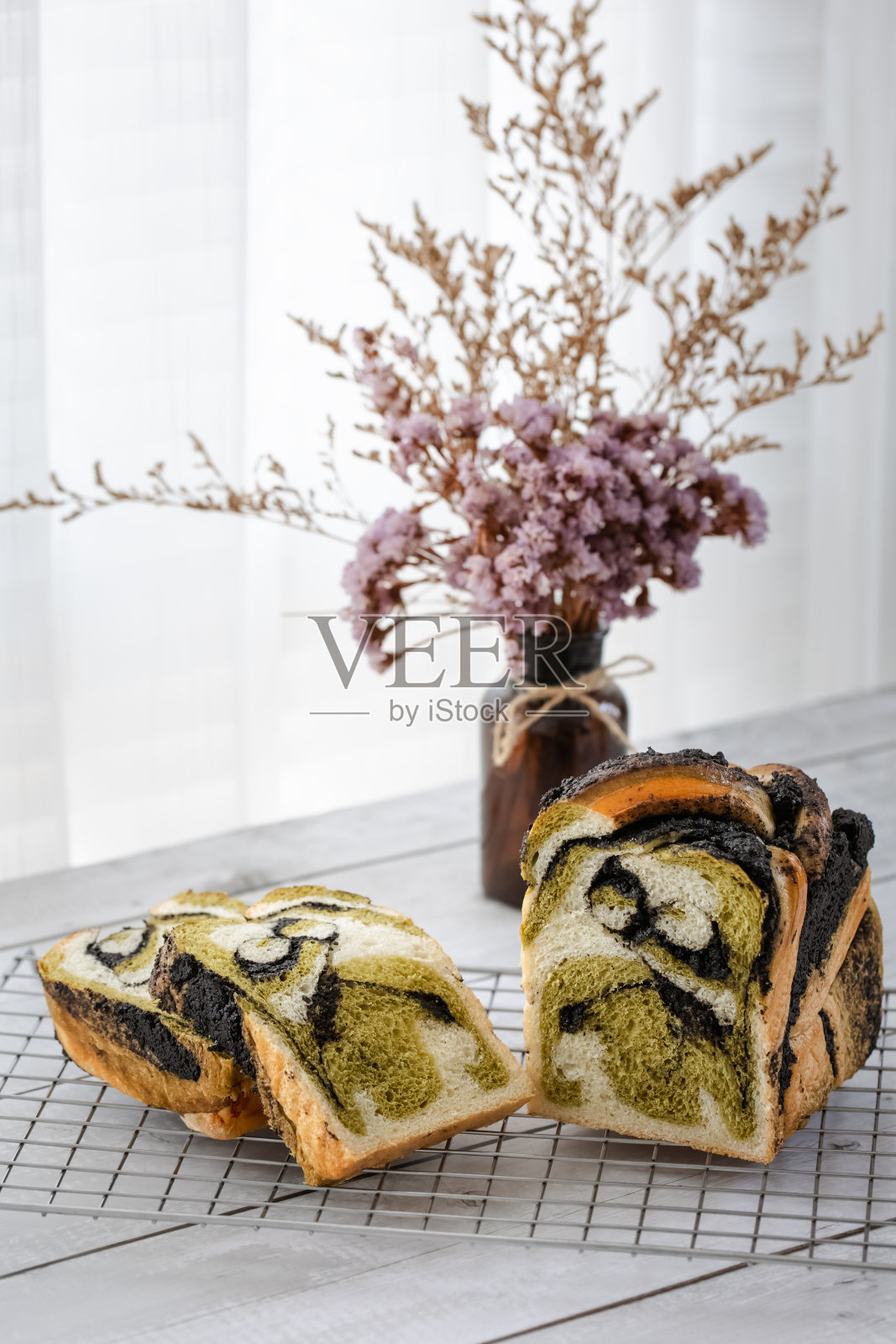 新鲜烘焙的黑芝麻绿茶布卡面包，切片放在架子上照片摄影图片
