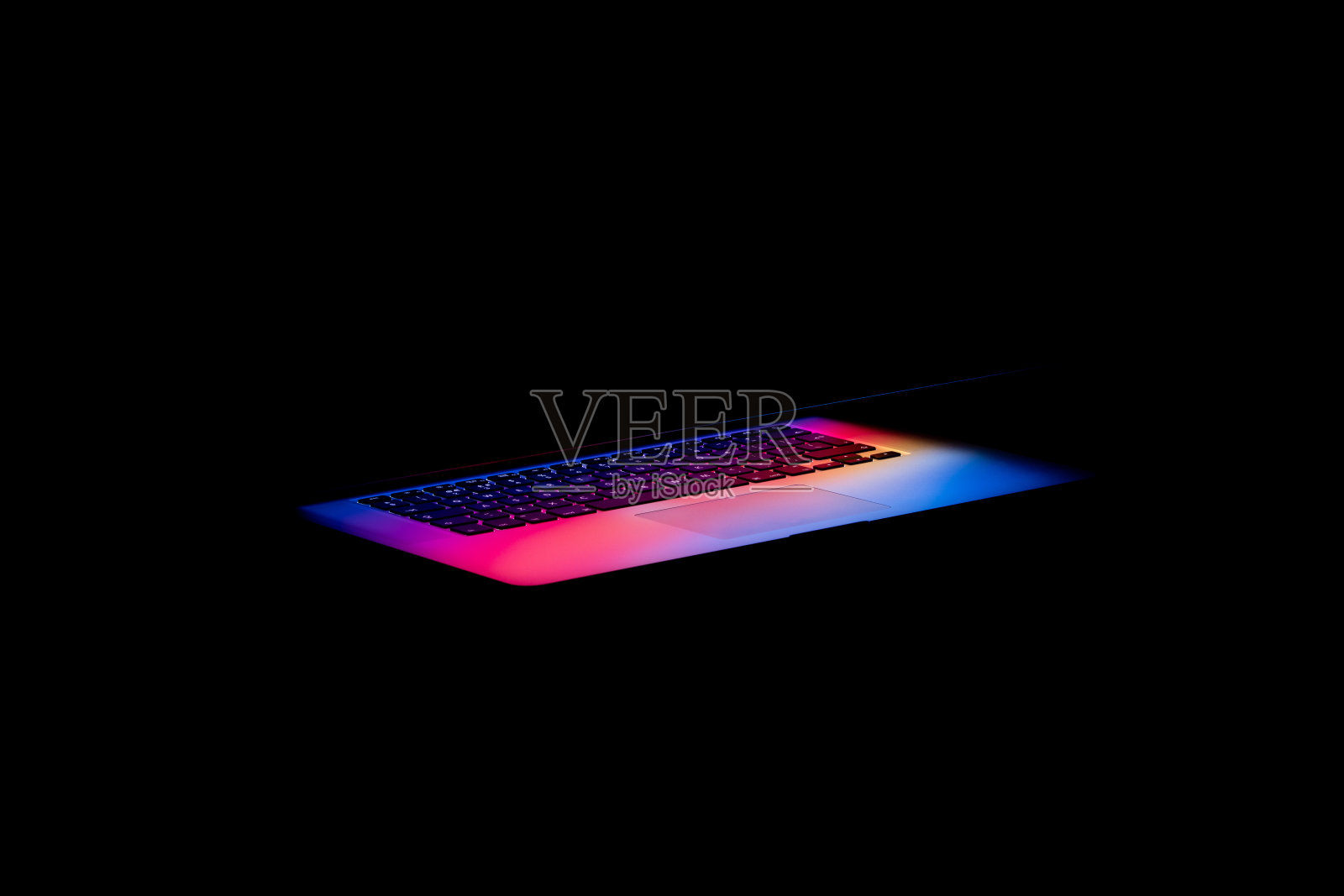 在黑暗中，彩色的光从笔记本电脑屏幕上发出照片摄影图片