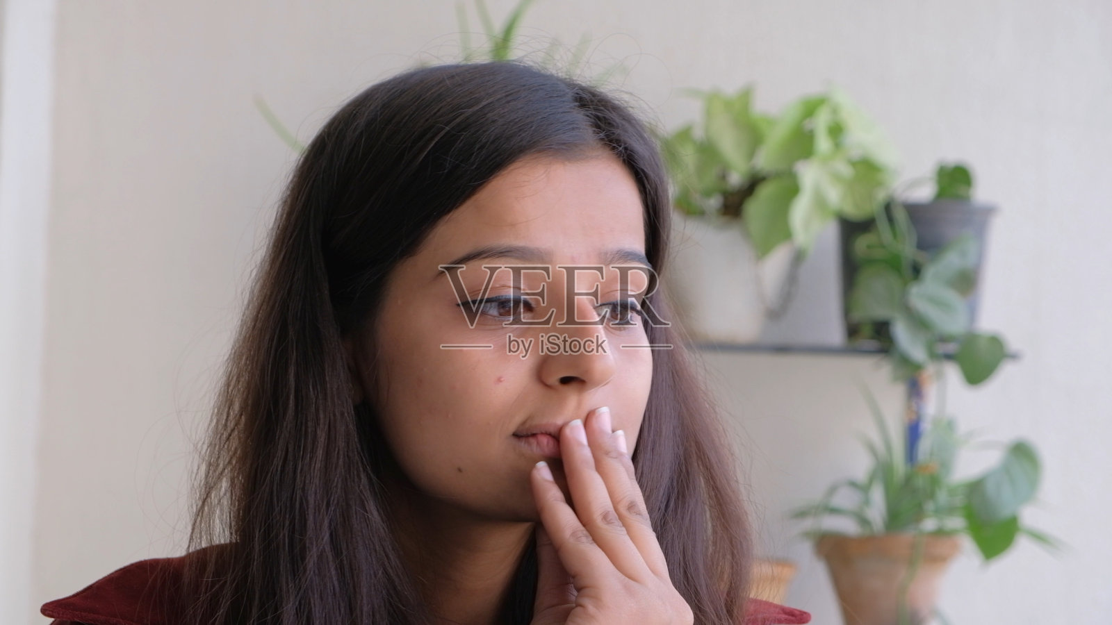 一个忧心忡忡的印度妇女在室内的浅聚焦照片摄影图片