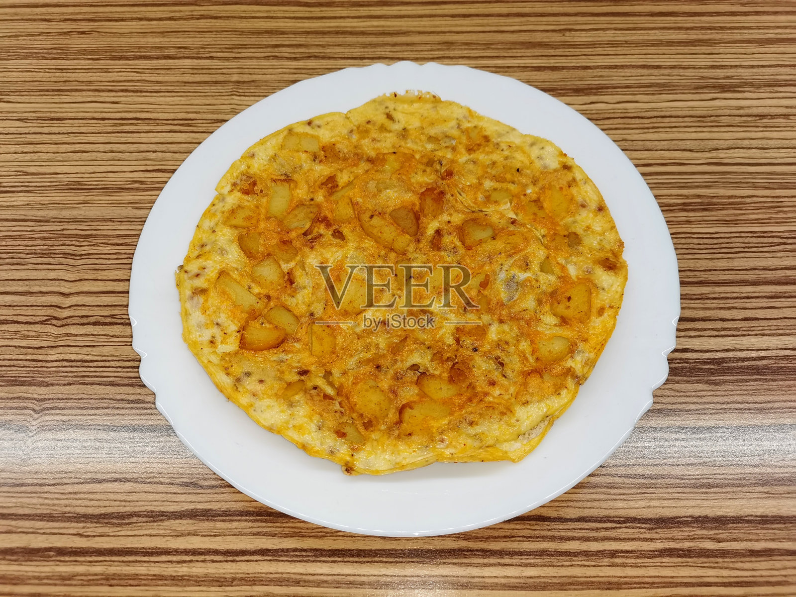 鸡蛋和土豆煎蛋卷，煎好后放在白色陶瓷盘上照片摄影图片